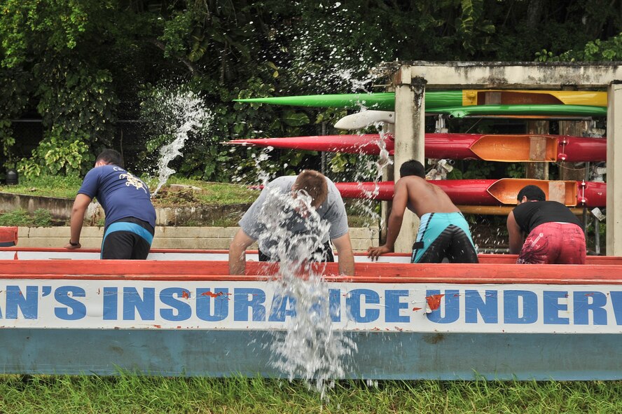 TAMUNING, Guam—Dragon Boat crew members drain out their boats prior to  the 2012 Second Annual 9/11 Commemorative Dragon Boat Race at Matapang Beach here, Sept. 22. This year’s boat race had ten-person teams that included personnel from the Guam Police Department, Andersen Air Force Base, deployed-in Kadena AFB Fire department, Guam Fire Department, Guam National Guard, Naval Fire Department, Navy Tag Five and the Haggan Outrigger Canoe Club. The dragon boat race consisted of eight separate heats, competing for time. The Guam Police Department took the overall win with 2:12.63 seconds. (U.S. Air Force photo by Staff Sgt. Alexandre Montes/Released)