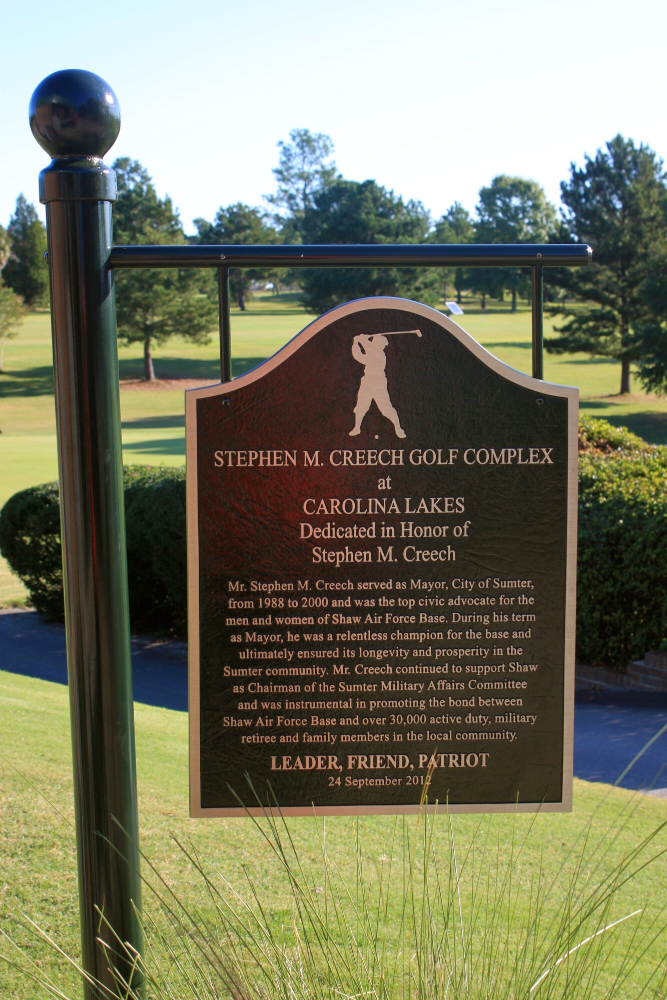 A dedication plaque is unveiled at the Stephen M. Creech Golf Complex after a surprise ceremony took place dedicating the complex to Creech, Sept. 24, 2012, Shaw Air Force Base S.C. Creech is a former City of Sumter Mayor and long time military supporter. Currently he is the Sumter Chamber of Commerce Military Affairs chairman and serves on the Air Combat Command Commander’s Group.  Creech’s family and several local civic leaders attended the dedication ceremony. (U.S. Air Force photo by 1st Lt. Ann Blodzinski/Released) 