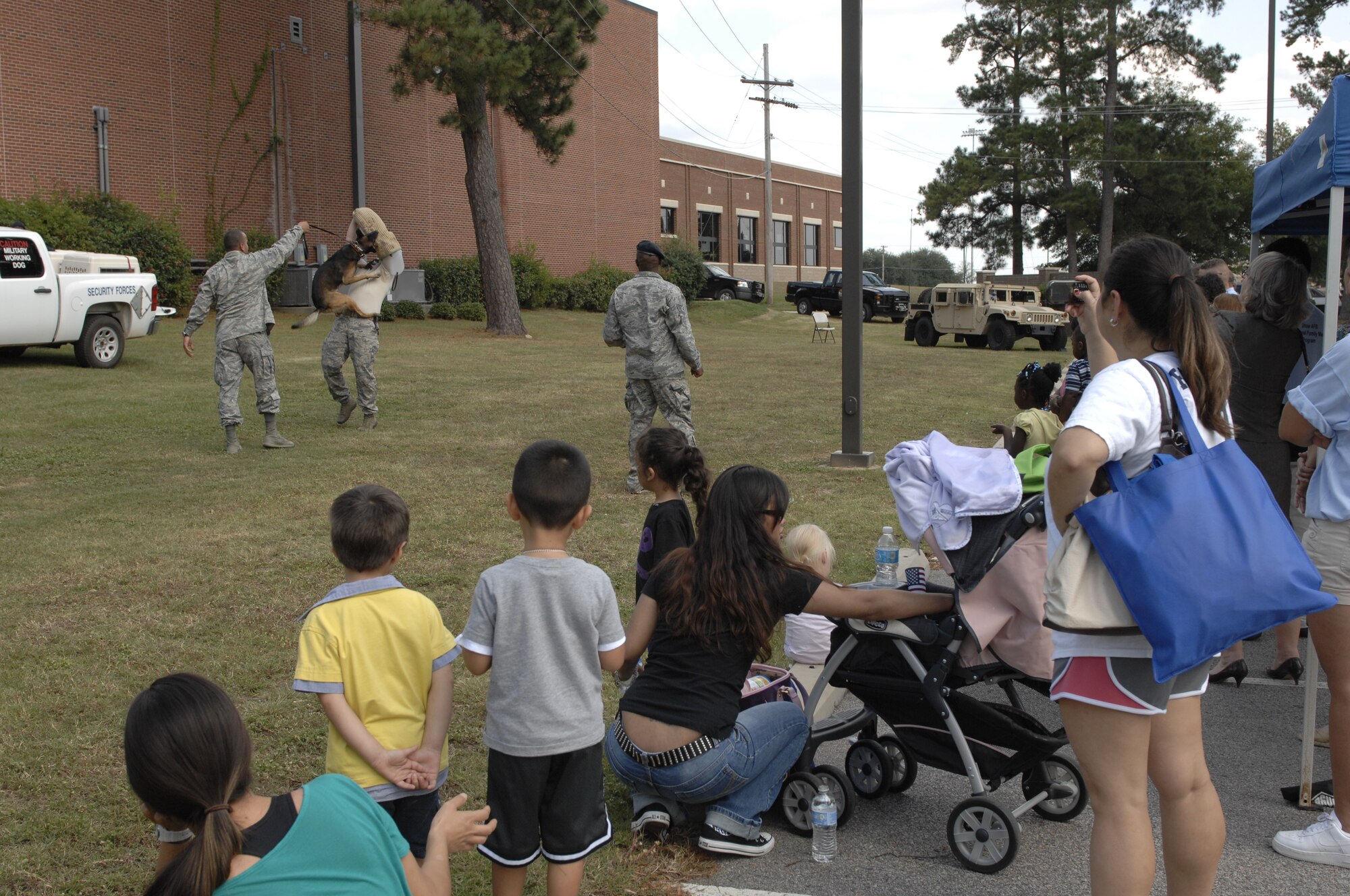The 20th Security Forces K-9 unit demonstrates the abilities of their dogs at the Child Find Clinic and Community Resources Awareness Fair at Shaw Air Force Base, S.C, Sept. 21, 2012. The fair was held by the 20th Force Support Squadron’s Exceptional Family Member Program. The purpose of the event was to discover children with special needs, introduce them to resources to help manage those needs, and to introduce families to others in similar situations. (U.S. Air Force photo by Airman 1st Class Krystal M. Jeffers/ Released)