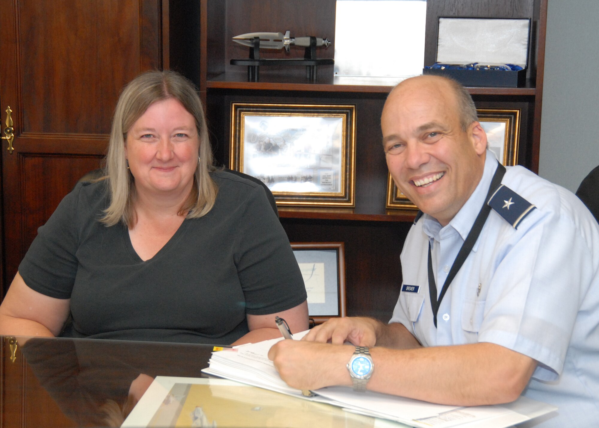 Rebecca Hobbs, Edwards AFB Environmental Management, presents Brig. Gen. Michael T. Brewer with the Site 3 Main Base Inactive Landfill Record of Decision for his signature Sept. 14. The Site 3 ROD is a set of remedies and agreements to clean up the unused landfill located in the north west region of the base. (U.S Air Force photo by Kenji Thuloweit)  