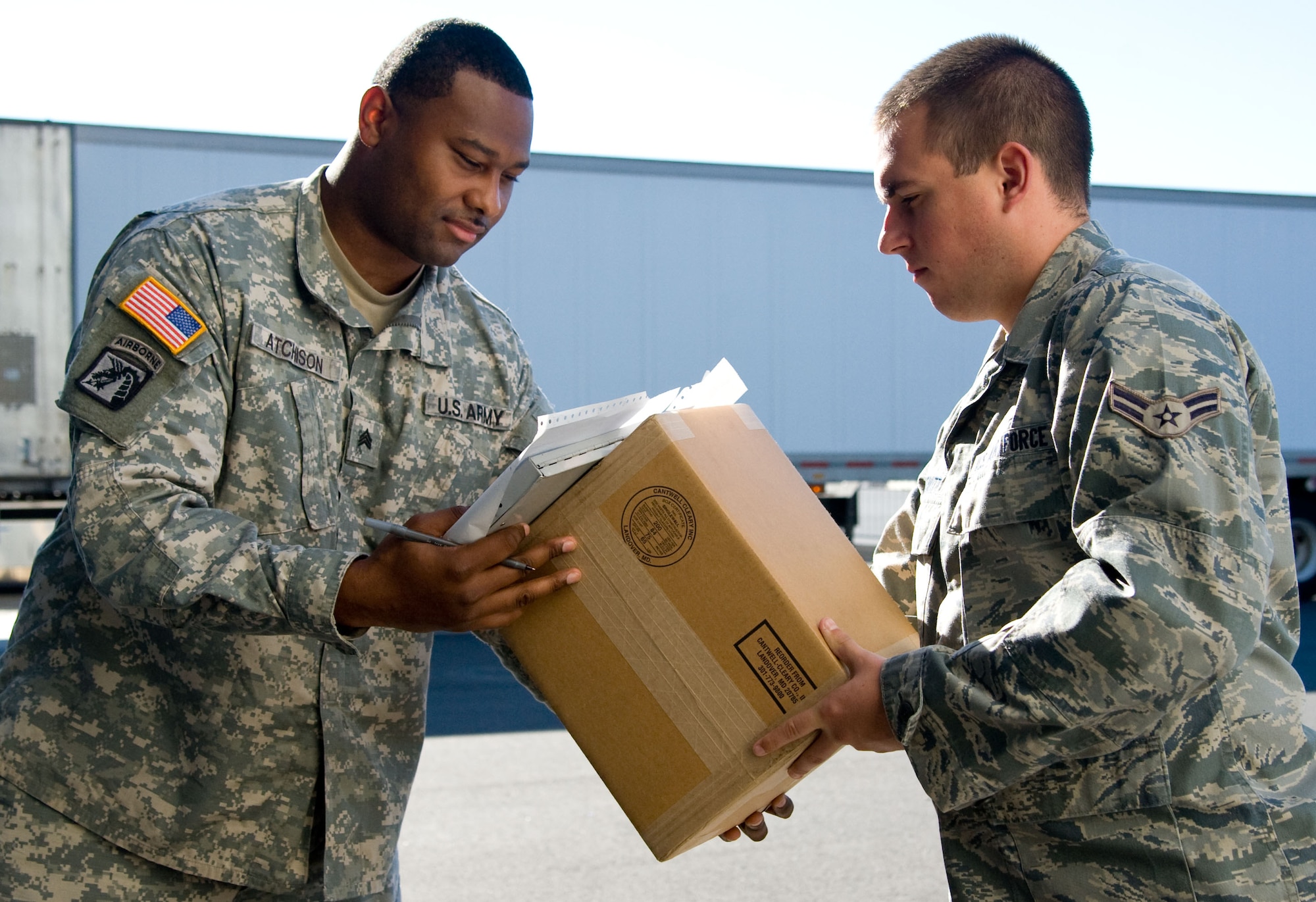 Army Sgt. Marcus Atchison, a Defense Courier Service courier based out of Fort Meade, Md., transfers a classified package to Airman 1st Class Don DeWitt, a communications security accountant with the 436th Communications Squadron, Sept. 25, 2012, at Dover Air Force Base, Del. The DCS couriers transport and deliver various packages throughout the world. (U.S. Air Force photo by Adrian R. Rowan)