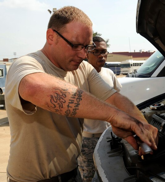 Tech. Sgt. Jeremie Ellsworth, 2nd Logistics Readiness Squadron Vehicle Maintenance customer service center, unscrews a panel as Senior Airman Anthony Avance, 2nd Aircraft Maintenance Squadron, observes on Barksdale Air Force Base, La., Sept. 25. The customer service section is in charge of quality checks and small repair jobs on vehicles before they are sent to the primary maintenance section. (U.S. Air Force photo/Airman 1st Class Andrew Moua)(RELEASED)