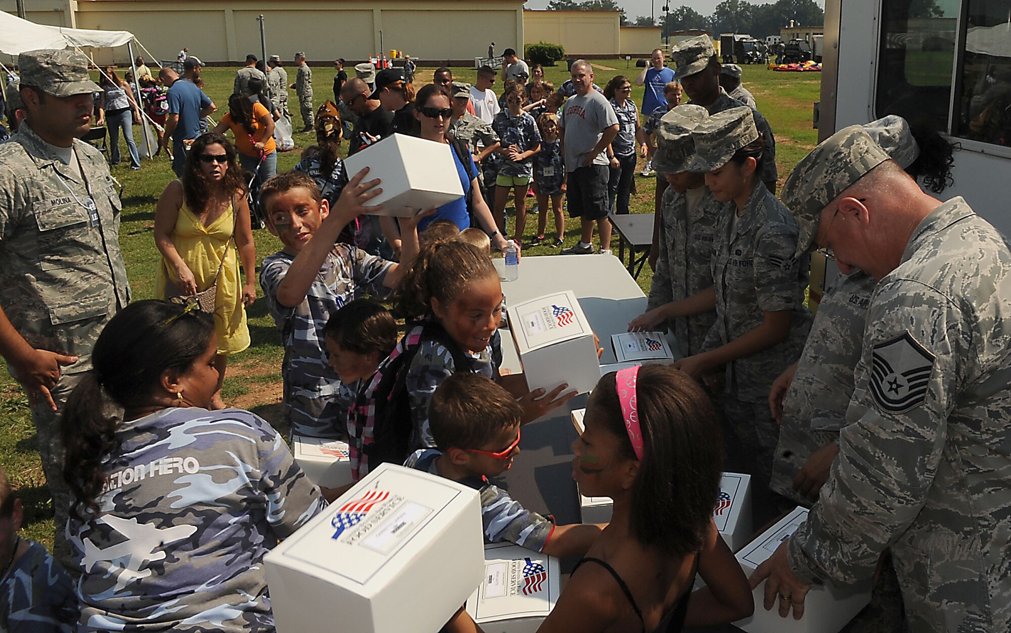 Children receive boxed lunches from members of the 2nd Force Support Squadron during Operation Hero on Barksdale Air Force Base, La., Sept. 22. The event, serving as a child-friendly personnel deployment line hosted 111 children. It featured a number of activities throughout the day, including a weapons qualification course with paintball guns, face-painting and a physical fitness assessment. (U.S. Air Force photo/Senior Airman Kristin High)(RELEASED)
