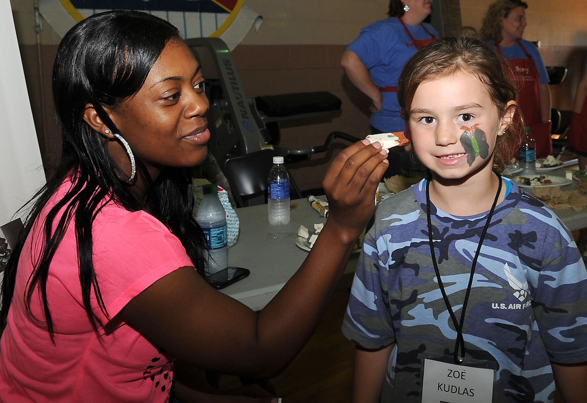 Staff Sgt. Cornelia Justice, 2nd Bomb Wing Protocol, paints a butterfly on Zoe Kudlas, 5, daughter of Maj. Devin Kudlas, Air Force Global Strike Command, during Operation Hero on Barksdale Air Force Base, La., Sept. 22. The annual event is a child-friendly personnel deployment line and features a number of activities for kids throughout the day. Children who registered for the event received a set of dog tags, a picture identification card and t-shirt. (U.S. Air Force photo/Senior Airman Kristin High)(RELEASED)

