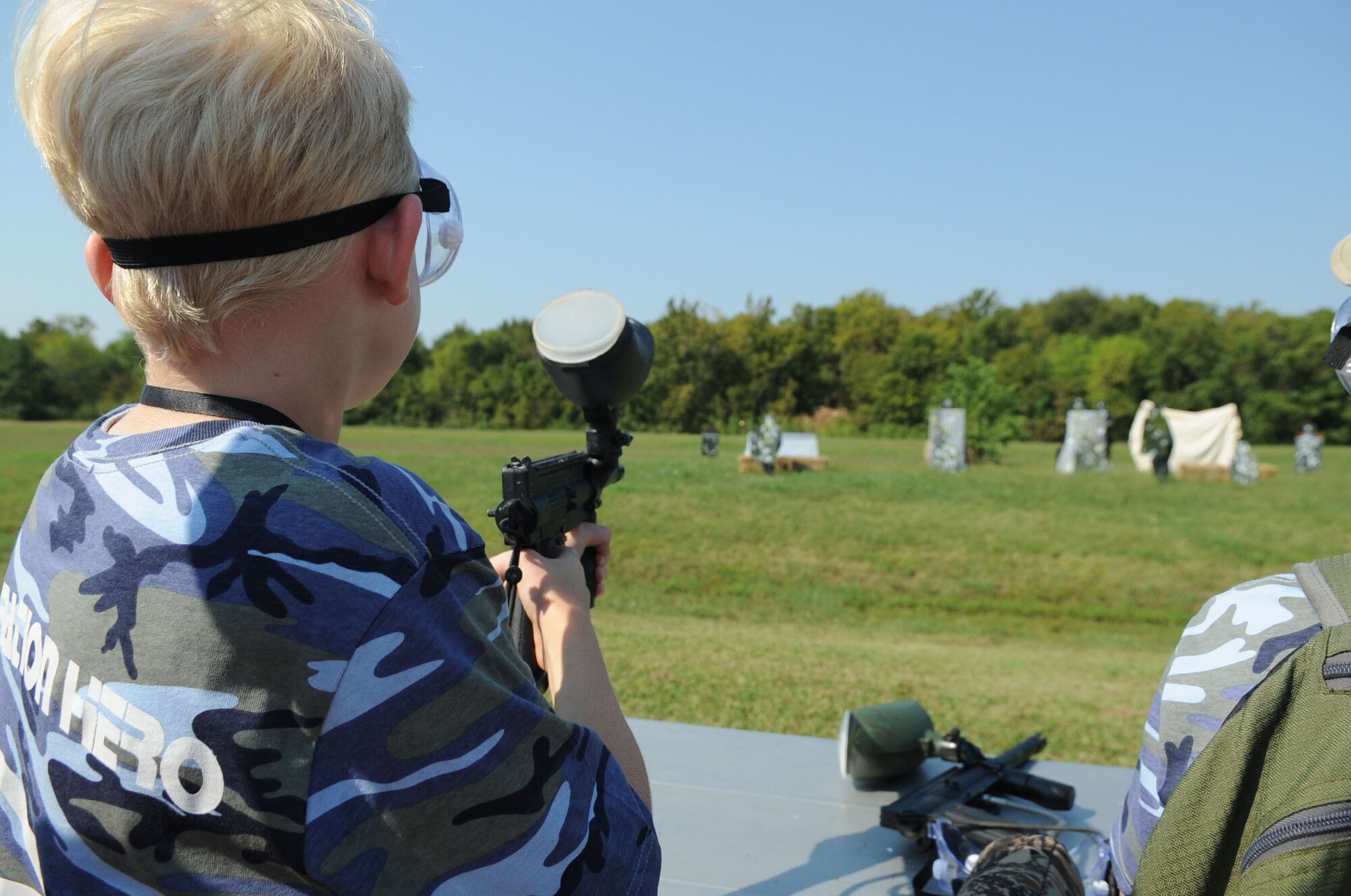 Colin Purtell, 10, son of Maj. Bryan Purtell, 2nd Bomb Wing Public Affairs Officer, aims a paintball gun at volunteers from Airman Leadership School class 12-6 during Operation Hero on Barksdale Air Force Base, La., Sept. 22. The annual event is a child-friendly personnel deployment line and features a number of activities for kids throughout the day, including a weapons qualification course with paintball guns, face-painting and a physical fitness assessment. (U.S. Air Force photo/Senior Airman Kristin High)(RELEASED)
