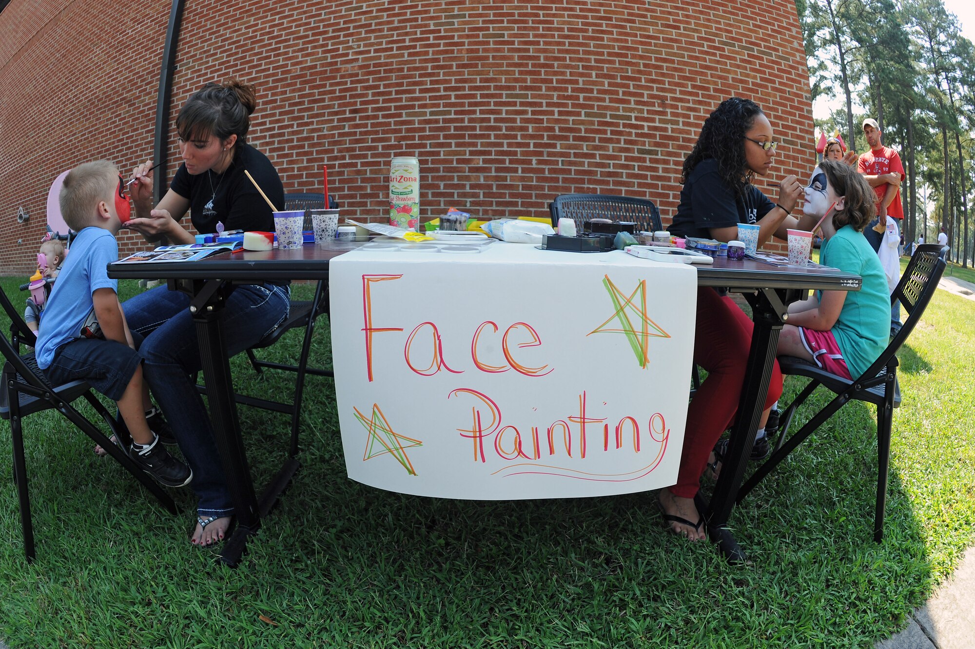 Volunteers paint children’s faces during the Worldwide Day of Play on Seymour Johnson Air Force Base, N.C., Sept. 22, 2012. The face painters offered a variety of designs to Team Seymour youth. (U.S. Air Force photo/Airman 1st Class John Nieves Camacho/Released)