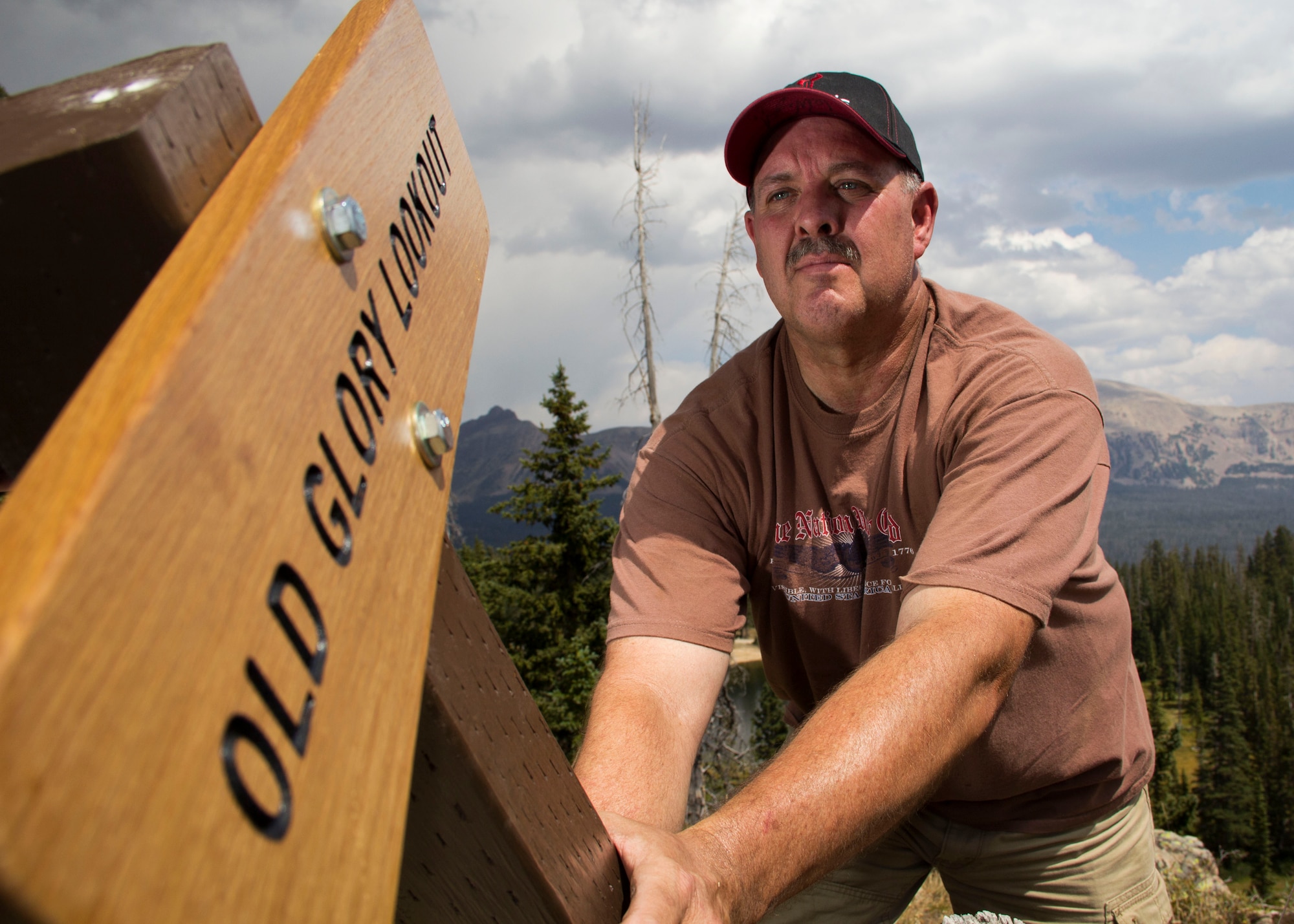 Master Sgt. Dave Graham, 419th Medical Squadron, grabs a sign to accompany the ashes of more than 150 U.S. flags. Graham personally bought the “Old Glory Lookout” sign to stake out the viewing area in the Uintah Mountains. Graham chose to bury the flags on the 31st anniversary of enlisting in the United States Air Force. (U.S. Air Force photo/Tech. Sgt. Richard Gonzales)
