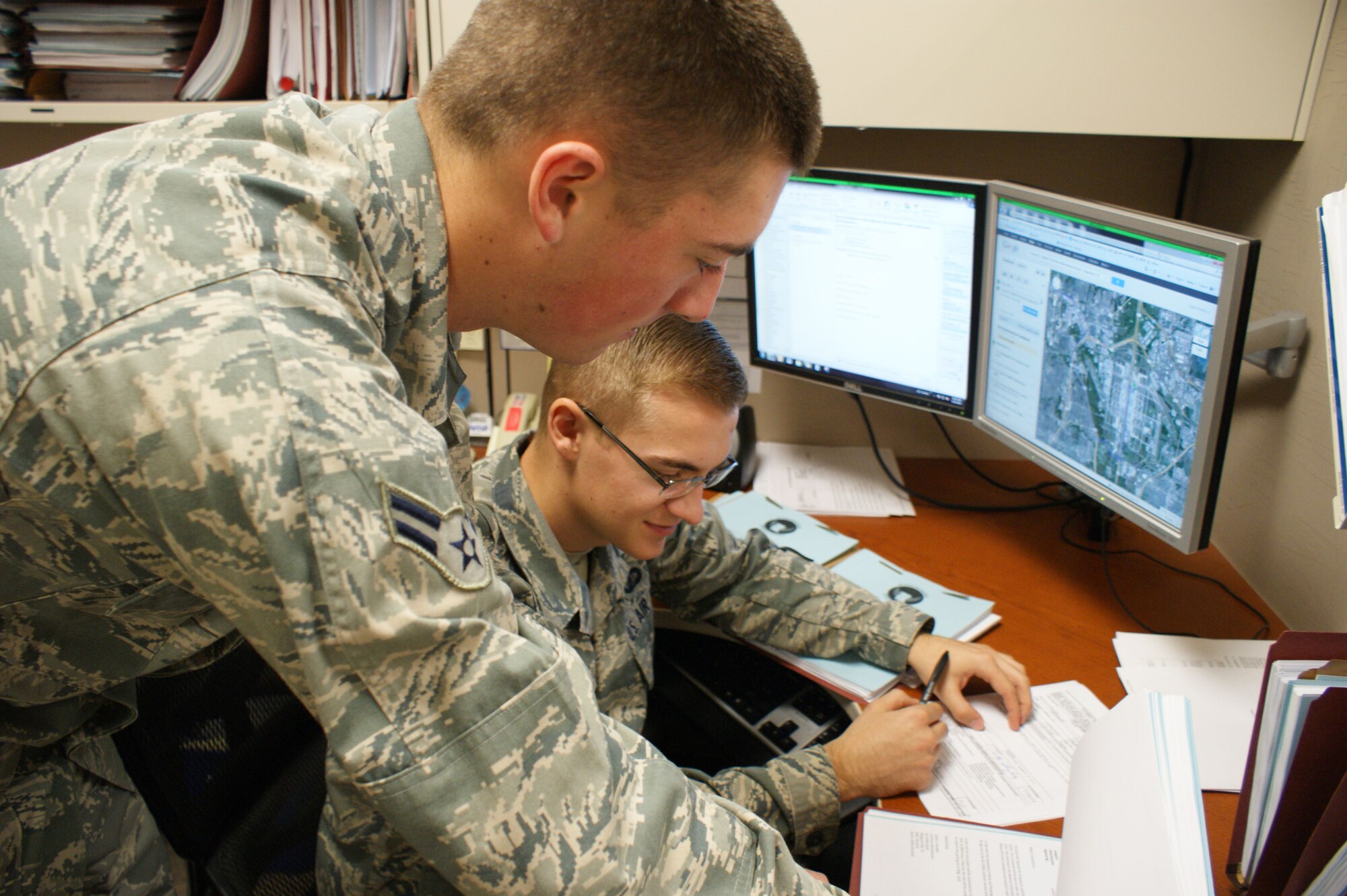 Contracting specialists Airmen 1st Class Justin Kondeff (foreground) and Dylan Huntley, 82nd Contracting Squadron, look over a contract during end-of-year closeout operations Sept. 20, 2012, at Sheppard Air Force Base, Texas.  End-of-year closeout during the month of September every year means long work hours for both the 82nd CONS and 82nd Comptroller Squadron.  (U.S. Air Force photo/Dan Hawkins)