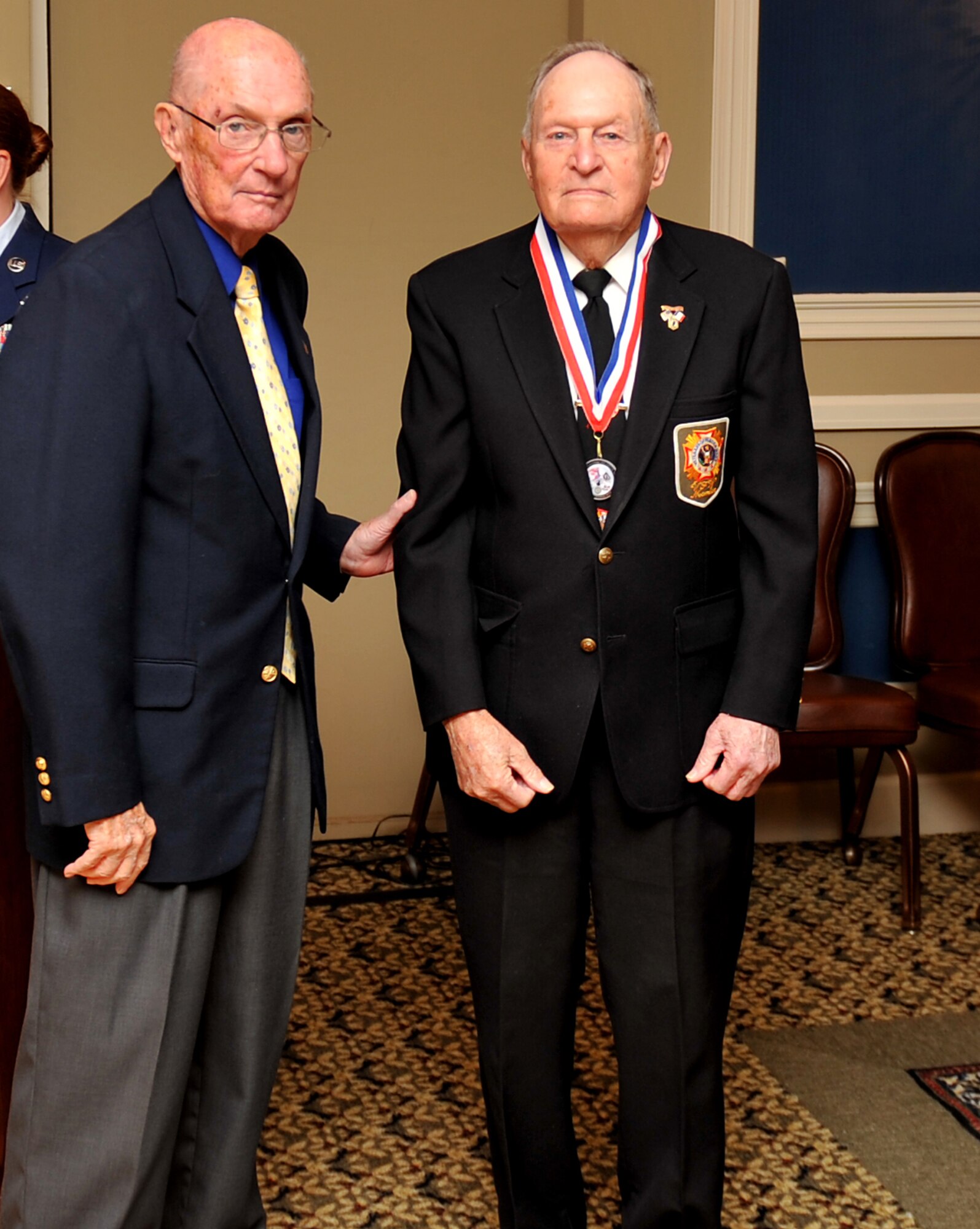 Retired Chief Master Sgt. of the Air Force James M. McCoy presents a medallion to retired U.S. Army Sgt. 1st Class Bill Roth, during a prisoner of war / missing in action remembrance luncheon at the Patriot Club, Neb., Sept. 21. Roth was one of nine former POWs who were honored during the remembrance luncheon for the sacrifices they made for their country. (U.S. Air Force photo by Jeff W. Gates/Released)