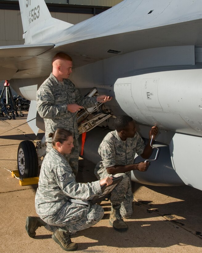 Instructor Staff Sgt Sara Sirmopoulos oversees the training of Airman 1st Class Max Edwards and Airman 1st Class Arthur Fortineau of the 362 Training Squadron, F-16 Mission Ready Airman class, practice opening a door for inspection on the F-16 aircraft on Sept. 10, 2012. (U.S. Air Force photo by Frank H. Carter)