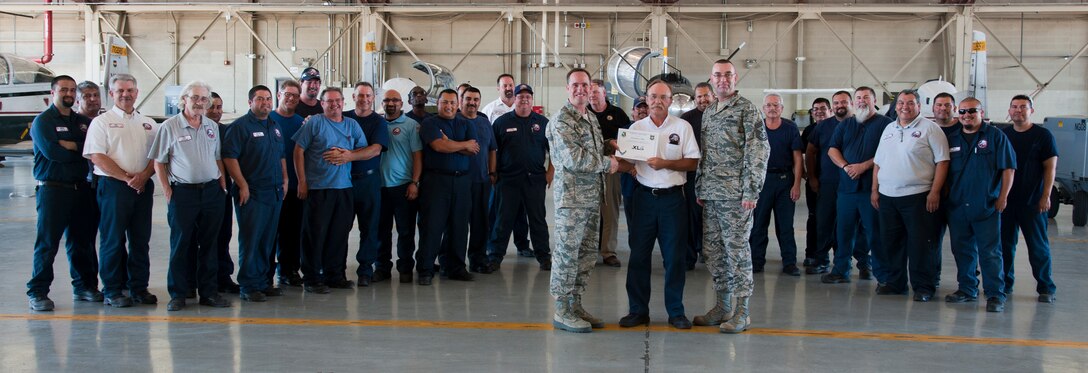 Dennis Miles, 47th Maintenance Directorate tools and parts supervisor, poses with Col. Tom Murphy, 47th Flying Training Wing commander, and Chief Master Sgt. Garry Berry, 47th FTW command chief, after being presented the XLer of the week award at Laughlin Air Force Base, Texas, Sept. 5, 2012. The XLer is a weekly award chosen by wing leadership and given to those who consistently make outstanding contributions to Laughlin and their unit. (U.S. Air Force photo/Airman 1st Class Nathan Maysonet)