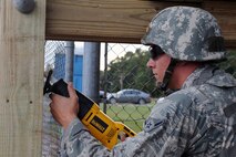 U.S. Air Force Airman Demetri Tsika, 4th Civil Engineer Squadron structural apprentice, saws slits into a drop arm during Phase II of Operational Readiness Exercise Coronet Warrior 12-04 at a simulated deployed location on Seymour Johnson Air Force Base, N.C., Sept. 20, 2012. Various simulations were conducted during the exercise to test Airmen’s abilities to react and respond in a wartime environment. (U.S. Air Force photo/Airman 1st Class John Nieves Camacho/Released)