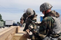 U.S. Air Force Airman Demetri Tsika (right) 4th Civil Engineer Squadron structural apprentice, and Senior Airman Jonathan Garcia, 4th CES structural journeyman, construct a drop arm during Phase II of Operational Readiness Exercise Coronet Warrior 12-04 at a simulated deployed location on Seymour Johnson Air Force Base, N.C., Sept. 20, 2012. Simulated wartime contingency exercises like CW 12-04 test an Airman’s ability to defend and execute the 4th Fighter Wing’s mission of providing precision combat airpower anytime, anywhere in a heightened state of readiness. (U.S. Air Force photo/Airman 1st Class John Nieves Camacho/Released)