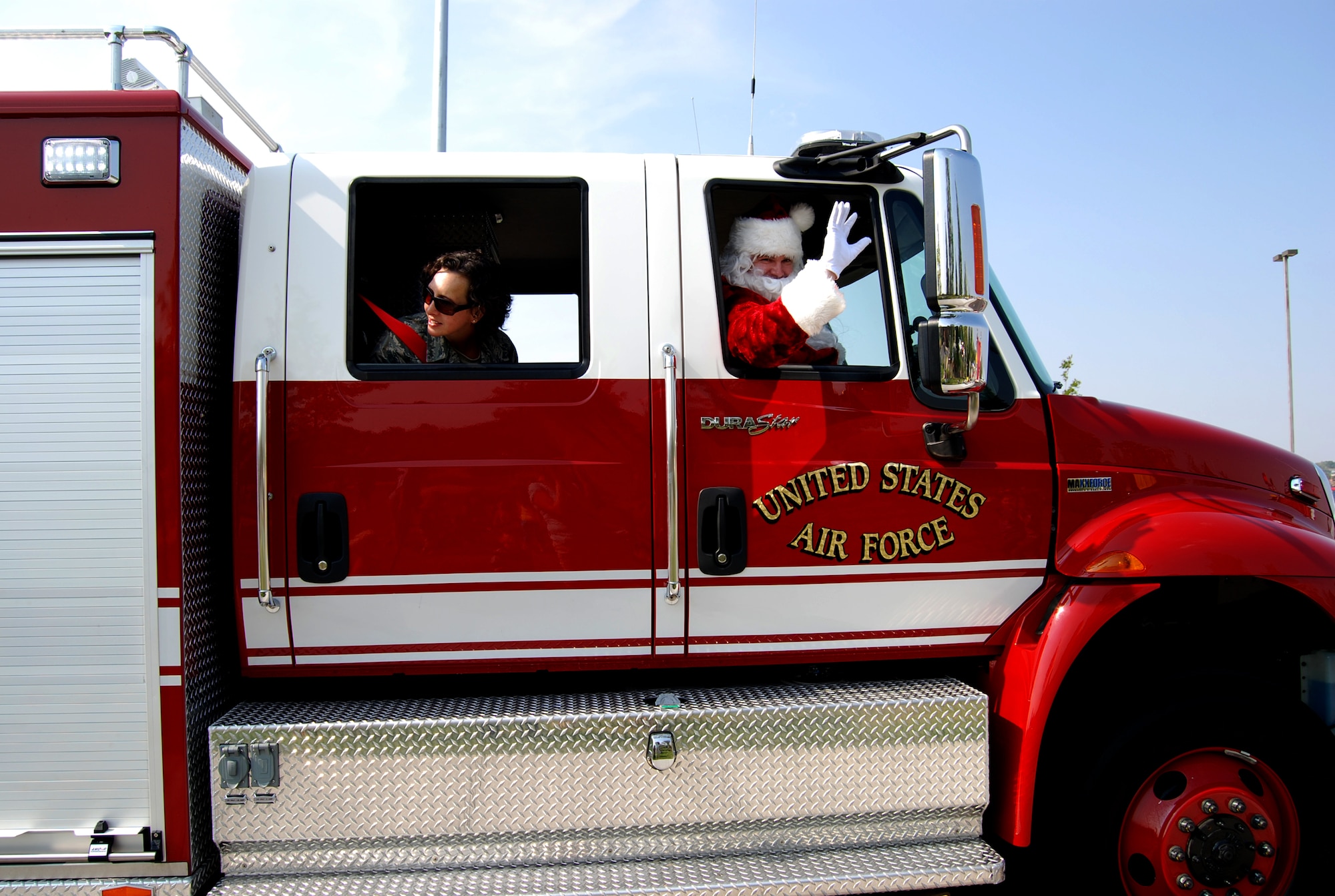 Santa waves to the crowd during the annual Snow Parade Sept. 19, 2012. The parade made stops at the main Child Development Center and the R.P. Lee Youth Center. Children were able to get inside the fire trucks, snow plows, and dump trucks, and were given stickers and snacks by Santa and his helper Master Sgt. Deanna Snider, 21st Civil Engineer Squadron first sergeant. The purpose of the Snow Parade is not only to educate children and the base populace, but also to ensure that all the equipment is in proper working order before the winter season. (U.S. Air Force photo/Lea Johnson)