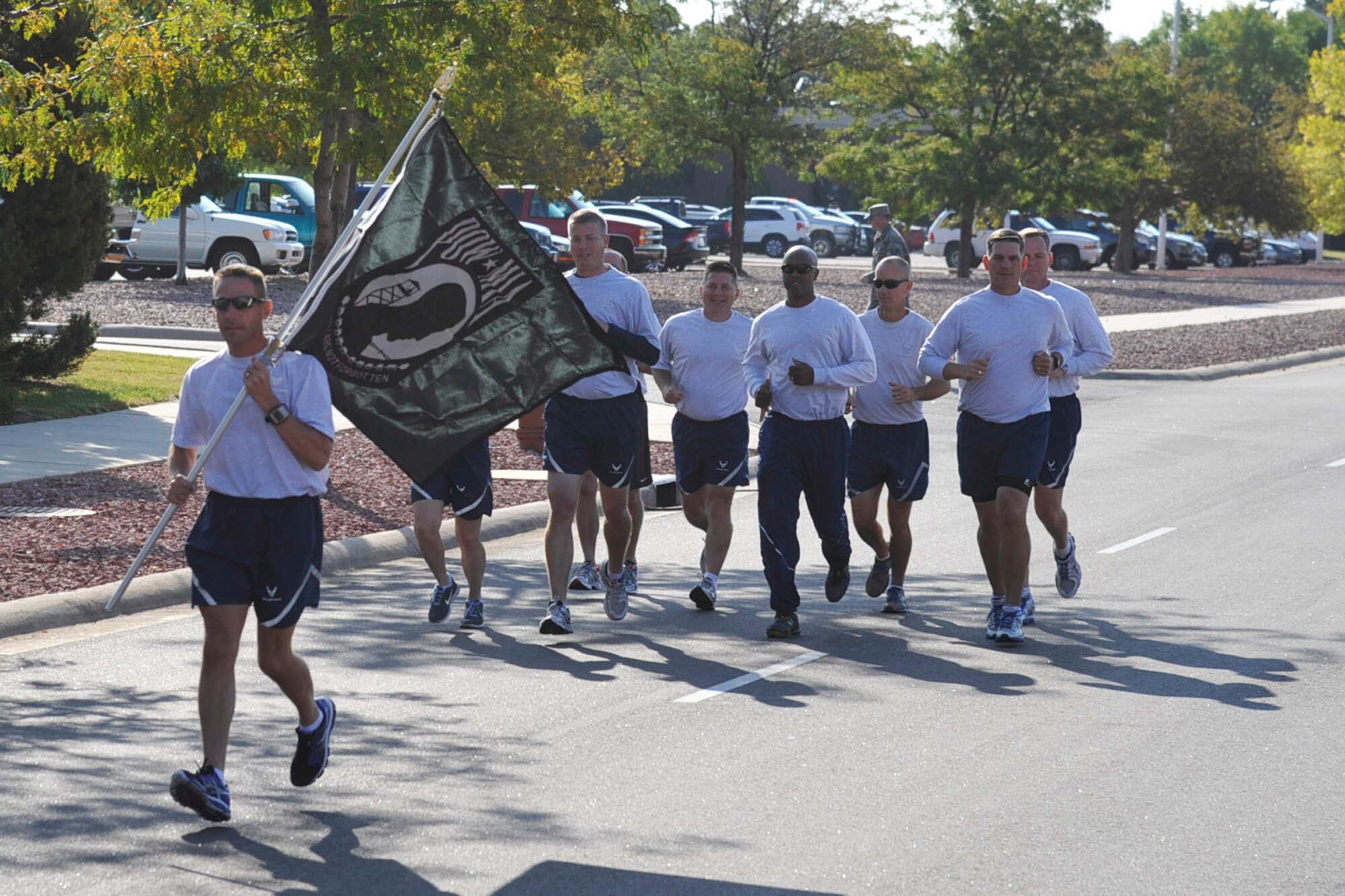 Senior leaders from the 21st Space Wing embark on a 24-hour POW/MIA run Sept. 20 beginning at the Vosler NCO Academy. The Airmen ran the flag one lap around base before handing the flag off to another team. Peterson service members will continue running the flag in shifts for 24 hours, culminating at the POW/MIA ceremony Sept. 21 at the base chapel. The ceremony was part of Peterson AFB POW/MIA week activities. (U.S. Air Force photo/Robb Lingley)