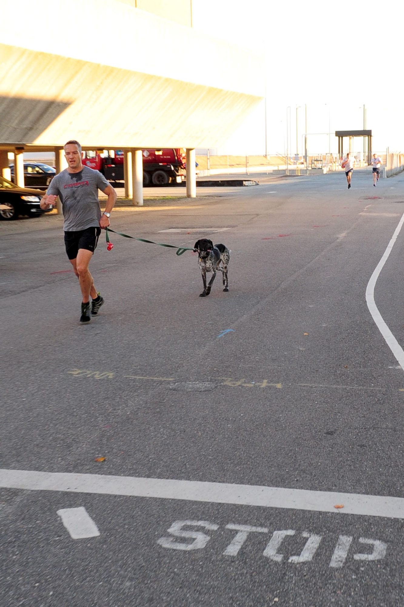 U.S. Air Force Lt. Col. Bo Bloomer, Headquarters, Air Combat Command chief of expeditionary engineering, and his dog Pepper, finish first during the Combined Federal Campaign 5K run at Langley Air Force Base, Va., Sept. 25, 2012. Bloomer completed the 5K with a time of 20:15. (U.S. Air Force photo by Staff Sgt. Ashley Hawkins/Released)