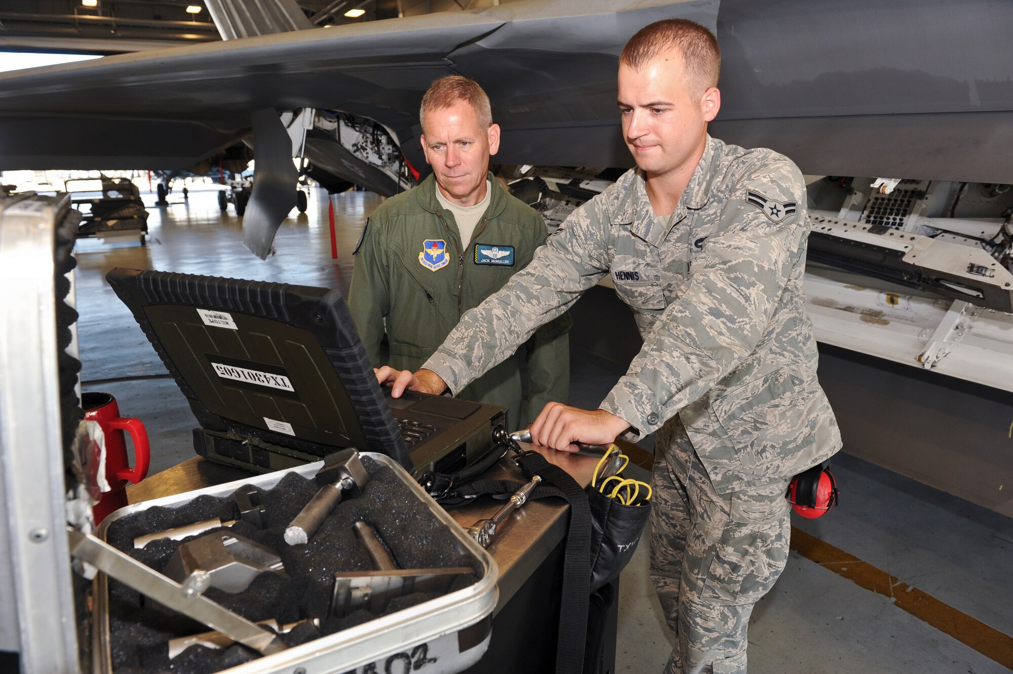 Airman 1st Class David Hennis, 325th Aircraft Maintenance Squadron weapons load crew member, shows Brigadier Gen. John McMullen, 325th Fighter Wing commander, his duties as a weapons load crew member during the Airman Shadow Program, Sept. 7. (U.S. Air Force photo by Chris Cokeing)
