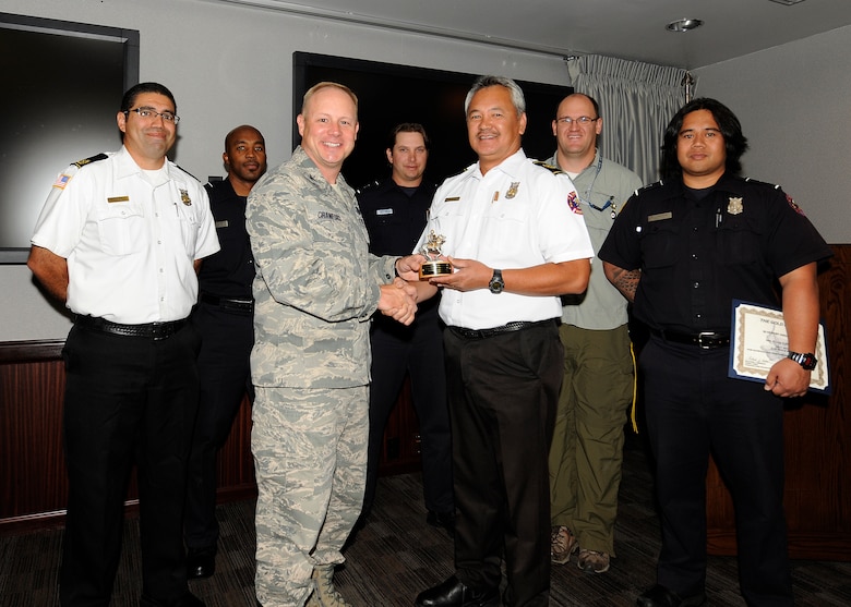 Col. Chris Crawford, 21st Space Wing commander, presents the Gold Knight award to the Waldo Canyon fire initial attack crew from the 721st Civil Engineer Squadron Sept. 19 in the wing conference room. The team consisted of Chris Soliz, Jesse Feldhauser, Brian Zimmerman, Elias Kunishige, Daryl Bolton, Richard Burgess and Tyler Nielsen. (U.S. Air Force photo/Rob Bussard)