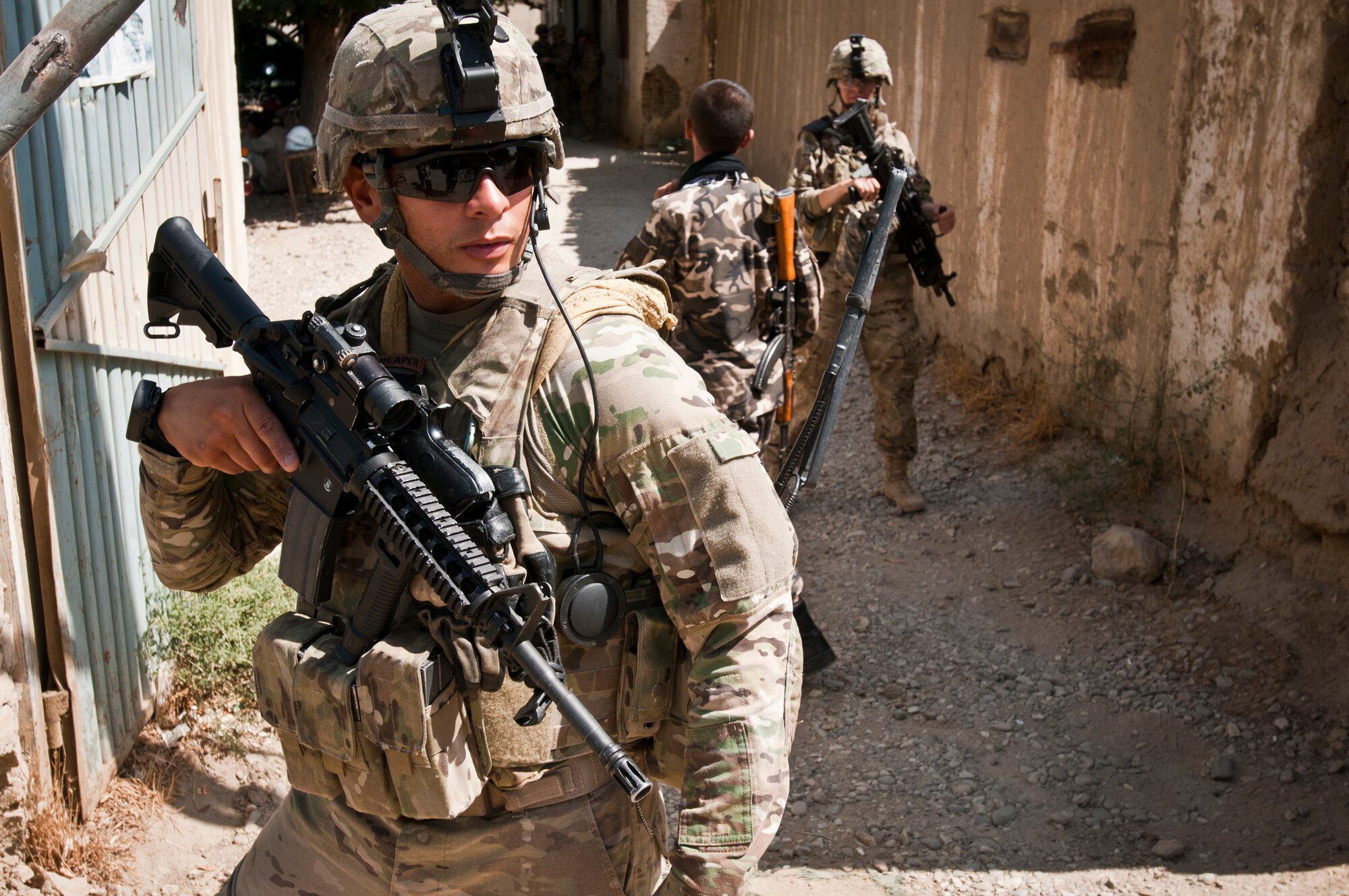 An Airman with the 455th Expeditionary Security Forces Squadron stands guard while Airmen deliver supplies to an Afghan National Police station outside Bagram Airfield, Afghanistan, Sept. 22, 2012. 455 ESFS is responsible for maintaining security on and around BAF to ensure safe operations. (U.S. Air Force photo/SMSgt Dale Canofari)