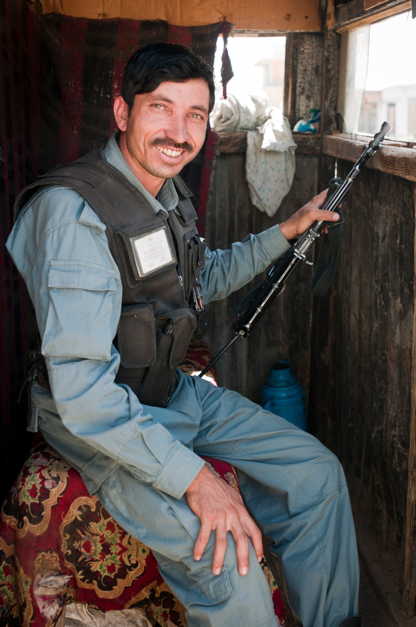 An Afghan National Police officer stands guard while Airmen deliver supplies to an Afghan National Police station outside Bagram Airfield, Afghanistan, Sept. 22, 2012. Bagram Airmen work closely with Afghan National Security Forces to maintain security around Bagram Airfield. (U.S. Air Force photo/SMSgt Dale Canofari)