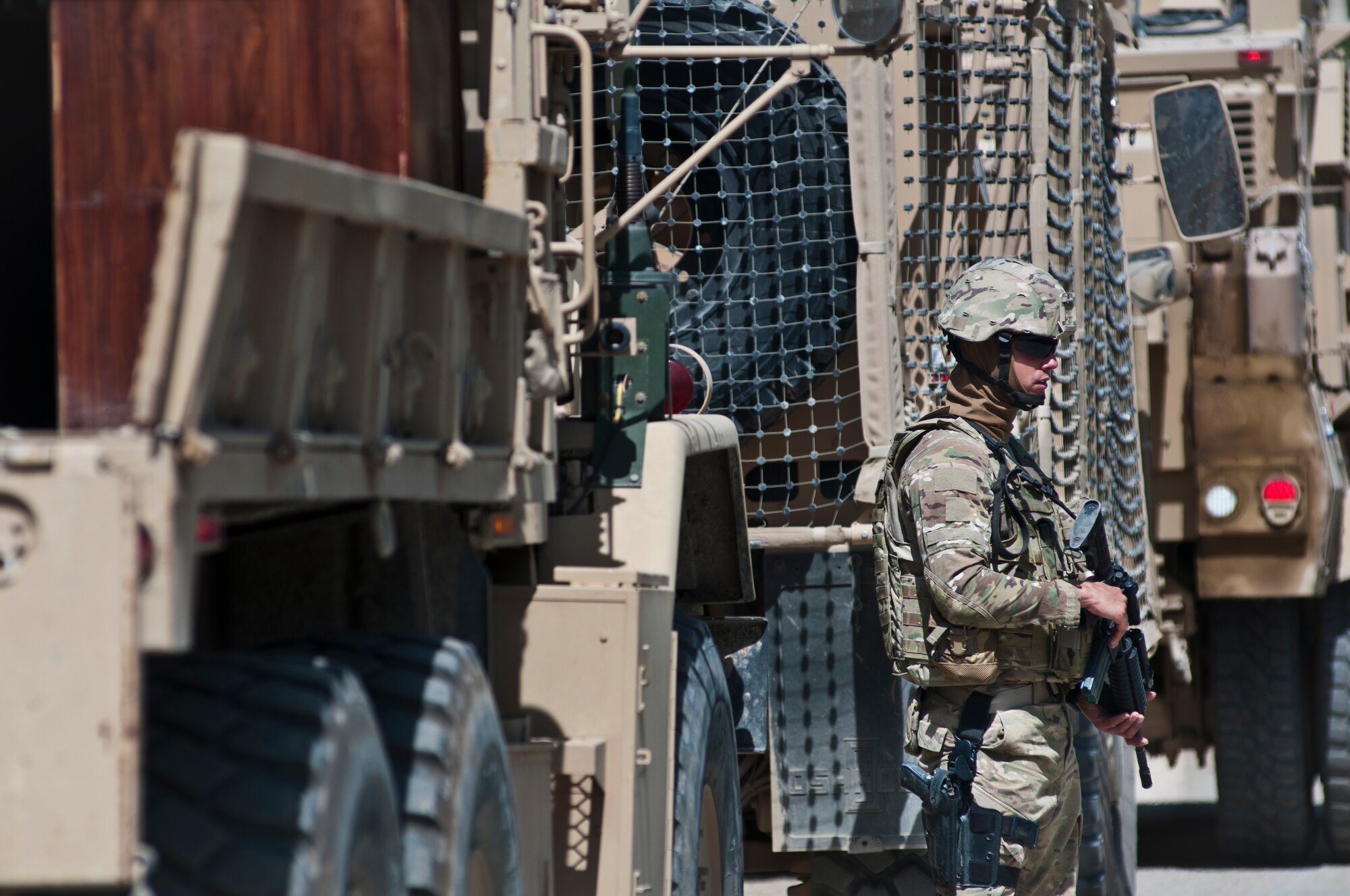 An Airman with the 455th Expeditionary Security Forces Squadron stands guard while Airmen deliver supplies to an Afghan National Police station outside Bagram Airfield, Afghanistan, Sept. 22, 2012. 455 ESFS is responsible for maintaining security on and around BAF to ensure safe operations. (U.S. Air Force photo/SMSgt Dale Canofari)
