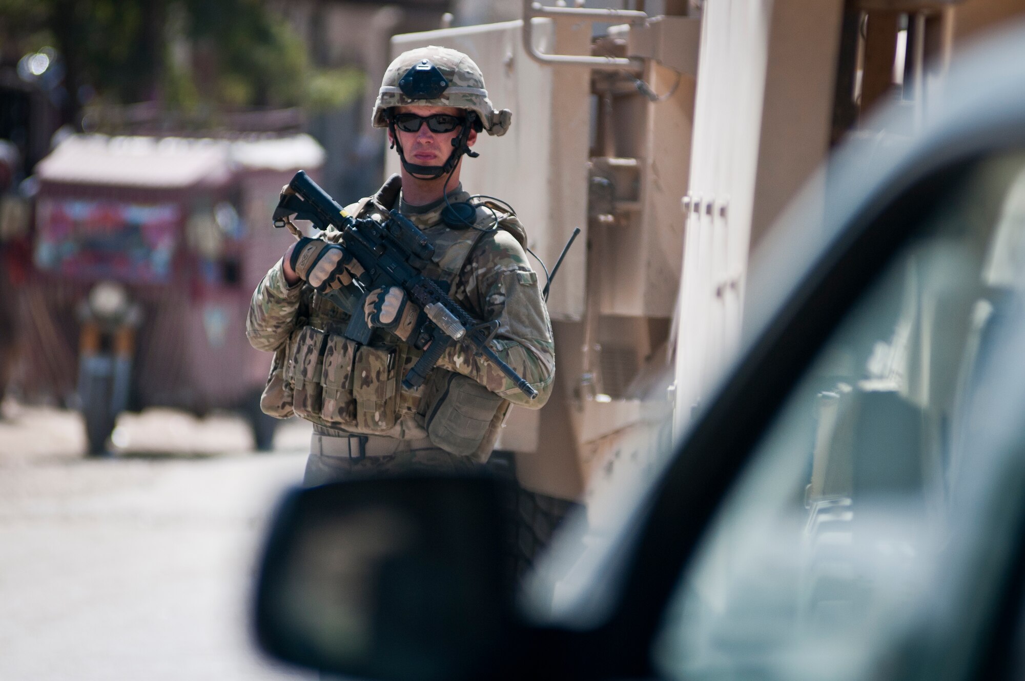 An Airman with the 455th Expeditionary Security Forces Squadron stands guard while Airmen deliver supplies to an Afghan National Police station outside Bagram Airfield, Afghanistan, Sept. 22, 2012. 455 ESFS is responsible for maintaining security on and around BAF to ensure safe operations. (U.S. Air Force photo/SMSgt Dale Canofari)