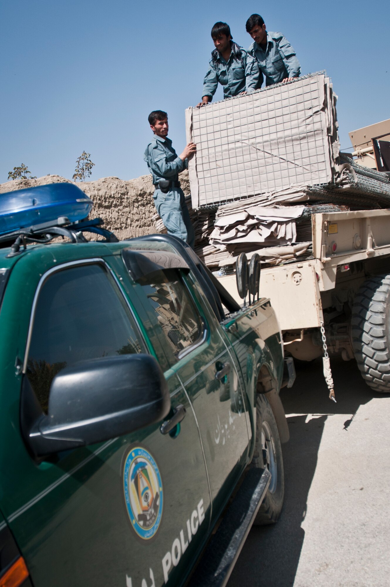 Afghan National Police officers off-load supplies provided by the 455th Expeditionary Security Forces Squadron from a truck at an ANP station outside Bagram Airfield, Afghanistan, Sept. 22, 2012. Bagram Airmen delivered security barriers and furniture to the Bagram District Police headquarters during the recent visit with their Afghan counterparts. (U.S. Air Force photo/SMSgt Dale Canofari)