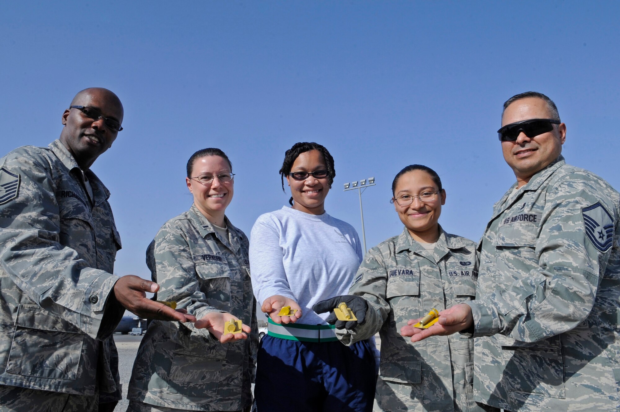 SOUTHWEST ASIA – Master Sgt. Mitchell Richardson, 386th Air Expeditionary Wing, 1st Lt. Jodie Verkleir, 386th Expeditionary Medical Group, Staff Sgt. Sharonda Murray, 387th Air Expeditionary Group, Senior Airman Ana Guevara, 386th Expeditionary Forces Support Squadron, and Master Sgt. James Rish, 386th EMDG, each found one of five golden bolts hidden on the flightline during the wing semi-annual foreign object debris walk here Sept. 22. More than 200 people participated and collected more than 300 pounds of trash. (U.S. Air Force photo/Staff Sgt. Alexandra M. Boutte)