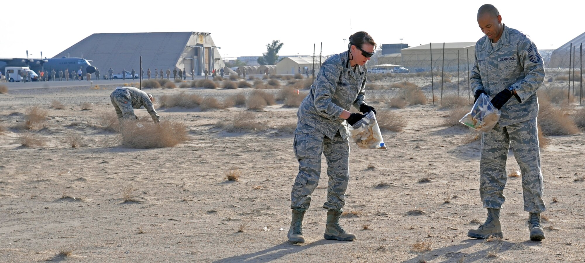 SOUTHWEST ASIA – Col. Virginia Garner, 386th Expeditionary Medical Group commander, and Chief Master Sgt. Thomas Leggett, 387th Air Expeditionary Group superintendent, pick up foreign object debris during the 386th Air Expeditionary Wing semi-annual FOD walk here Sept. 22. More than 200 people participated and collected more than 300 pounds of trash. (U.S. Air Force photo/Staff Sgt. Alexandra M. Boutte)