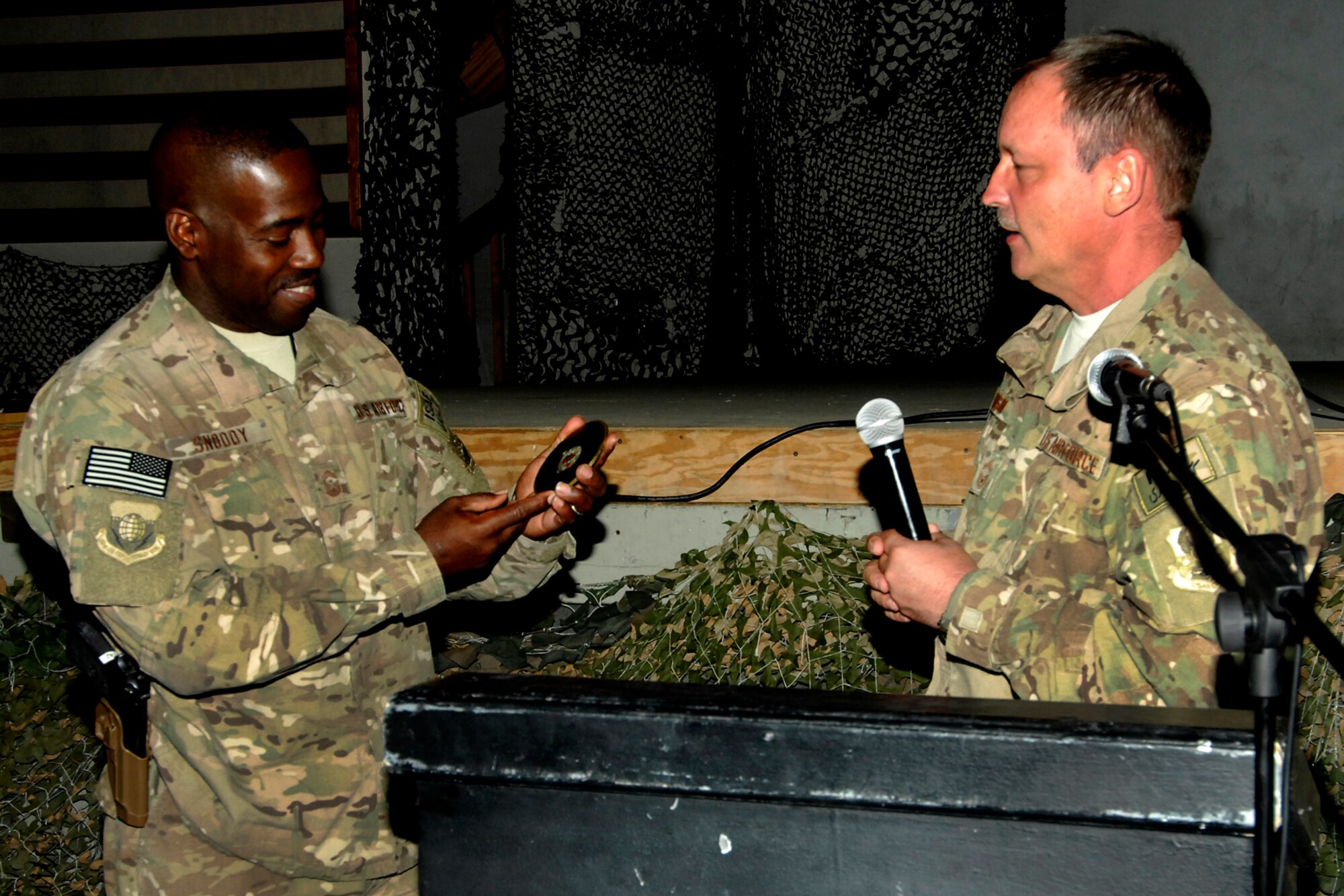 Command CMSgt Marcus Snoddy (left), 455th Air Expeditionary Wing command chief, is presented a memento from CMSgt Raymond Dawson, 455th Expeditionary Mission Support Group superintendent, during Snoddy’s going-away ceremony at Bagram Airfield, Afghanistan, Sept. 23, 2012. Snoddy encouraged Airmen and Soldiers to continue to do their best to make the mission a success in Afghanistan. Chief Snoddy had been the 455 AEW Command Chief since Sept. 2011. (U.S. Air Force photo/SSgt Jeff Nevison)