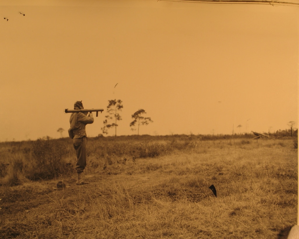 Soldier carries rocket launcher on shoulder.