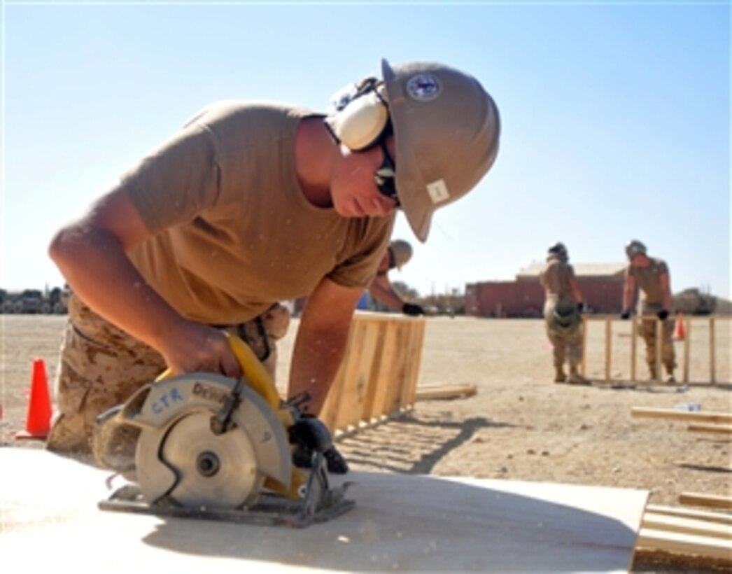 Navy Constructionman Carrie Ernst cuts a sheet of plywood during the construction of a K-span building project at Camp Leatherneck, Afghanistan, on Sept. 20, 2012.  Ernst is assigned to Echo Company of Naval Mobile Construction Battalion 133.  The battalion is deployed to conduct engineer construction efforts across the U.S. Central Command area of operations. 
