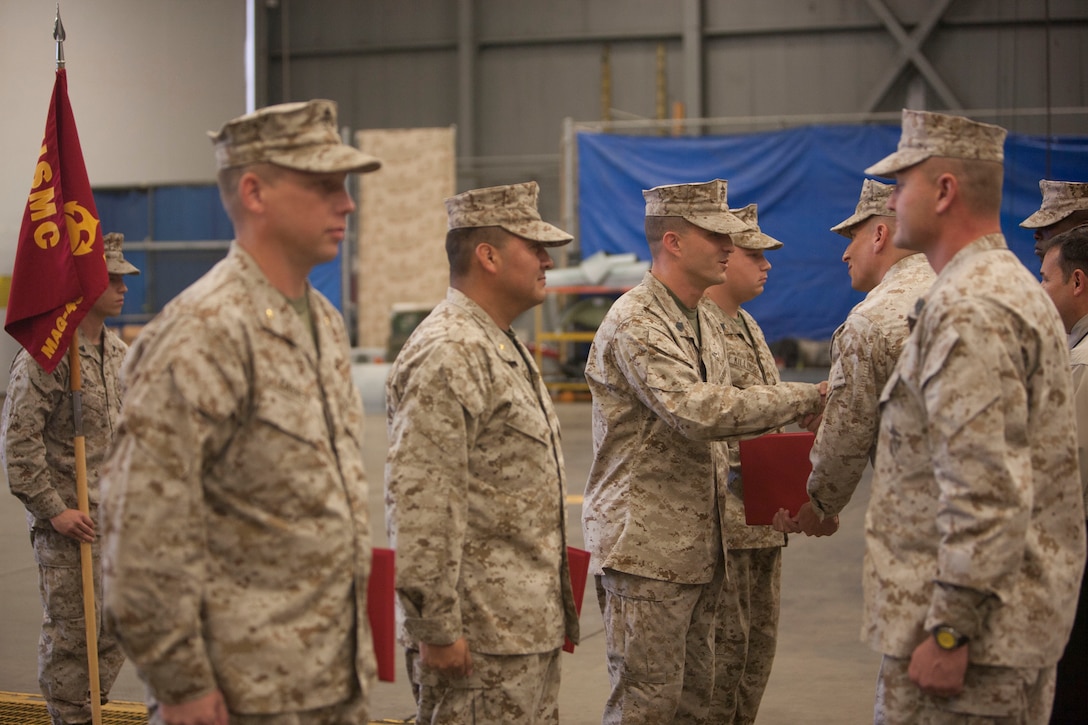 Maj. Gregory Earnest, Maj. Luis Gomez, Gunnery Sgt. Kenneth Medearis and Sgt. Raymond Killinger stand in formation as Lt. Col. Mark A. Sexton awards these Marines for logging mishap-free flight hours in the CH-46E helicopter. Marines received the awards during a ceremony held at the HMM-774 headquarters at Naval Station Norfolk on Sept. 20, 2012.