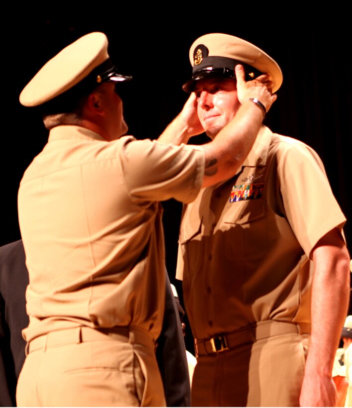 A chief petty officer has his new military uniform cap placed on his head by his sponsor during ceremony held aboard Marine Corps Base Camp Lejeune Sept. 14.  Sponsors prepare the chief petty officers mentally and physically for the challenges they will encounter in their new roles.