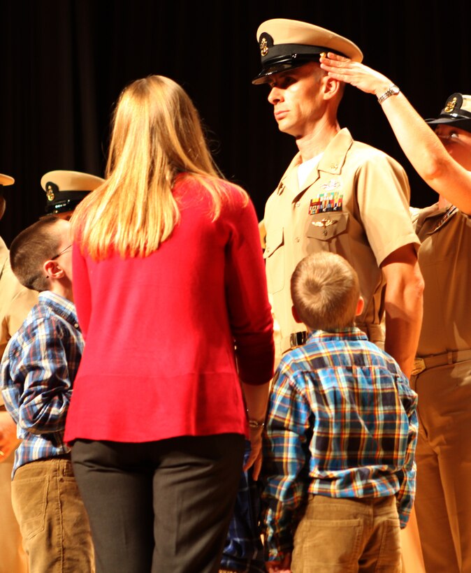 A chief petty officer has his new military uniform cap placed on his head by his sponsor while his family watches during ceremony held aboard Marine Corps Base Camp Lejeune Sept. 14.  Sponsors prepare the chief petty officers mentally and physically for the challenges they will encounter in their new roles.  