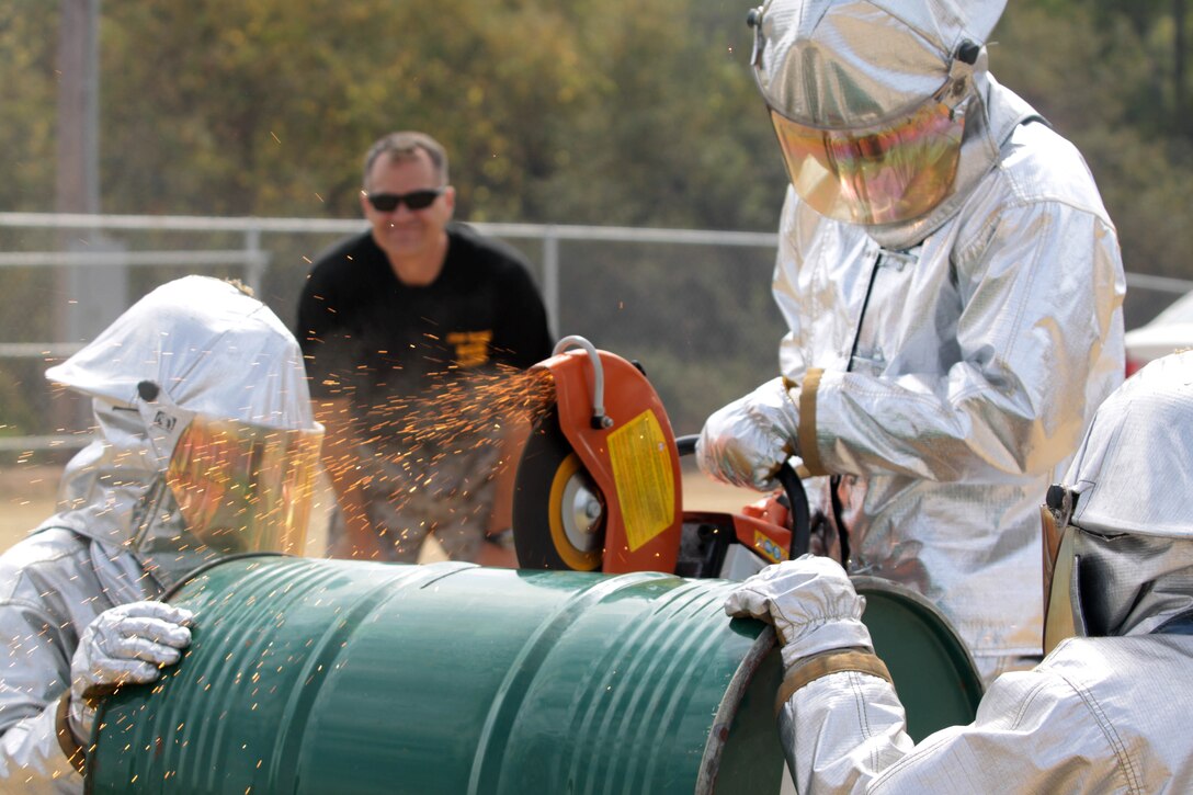 The Marine Corps Air Station Camp Pendleton team races to cut through a metal drum faster than the MCAS Yuma and MCAS Miramar teams during the 2012 Aircraft Rescue Fire Fighting Rodeo at Lake O'Neil aboard Marine Corps Base Camp Pendleton, Calif., Sept. 22. Pendleton won this event with a time of 27 seconds and 88 milliseconds.
