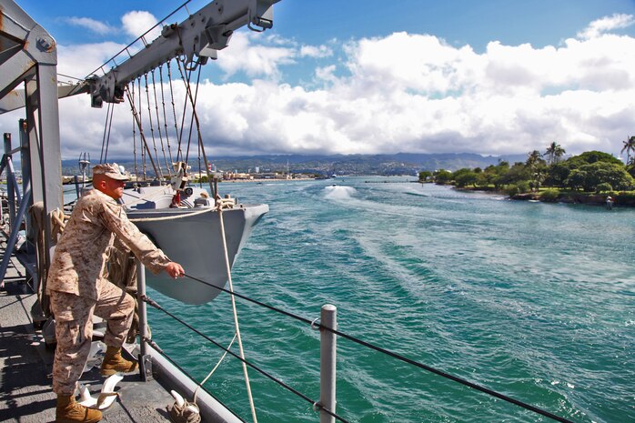 A Marine from the 15th Marine Expeditionary Unit watches as the USS Rushmore leaves U.S. Naval Base Pearl Harbor, Hawaii, a week into the unit?s Western Pacific Deployment, Sept. 25. The MEU and Peleliu Amphibious Ready Group will continue their deployment, where they plan to conduct theater security cooperation exercises and humanitarian operations.::r::::n::::r::::n::