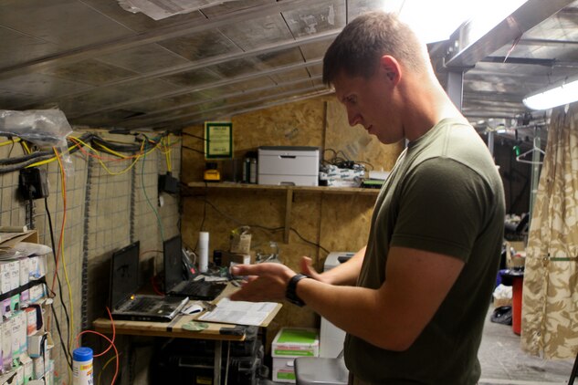 Petty Officer 2nd Class Jordan Fitzgerald, a corpsman with the battalion aid station, 2nd Battalion, 7th Marine Regiment, sterilizes his hands before moving to his next job, Sept. 25. Fitzgerald uses his experience as a Marine to better serve his patients.