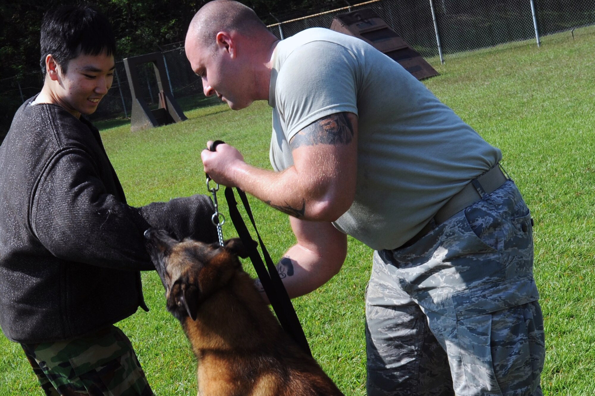 Senior Airman Otho Nugent, 51st Security Forces Squadron military working dog handler, commands his MWD to release Republic of Korea Air Force Staff Sgt. Yook, Young-Il, during a demonstration at the Osan Air Base kennel Sept. 24, 2012. Four members of the ROKAF Air Police Squadron had the chance to wear a ‘bite jacket’ and experience take down procedures during the demonstration. (U.S. Air Force photo/Airman 1st Class Alexis Siekert)