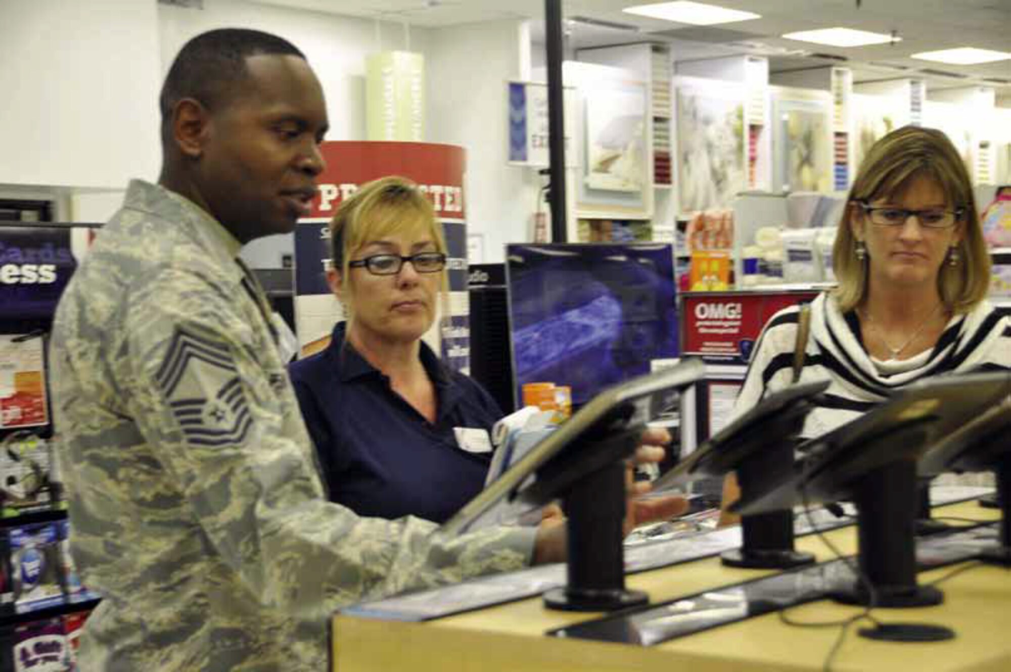 Chief Master Sgt. Tony Pearson, Army & Air Force Exchange Service Senior Enlisted
Advisor, discusses laptop features with Holly Elliott, March Exchange assistant manager, while Tina Lovitt, Exchange West Coast area manager reviews the electronics display at the March Exchange Sept. 12. Pearson arrived from Texas to meet with Team March customers and associates and tour the Exchange. (U.S. Air Force photo by Linda Welz)