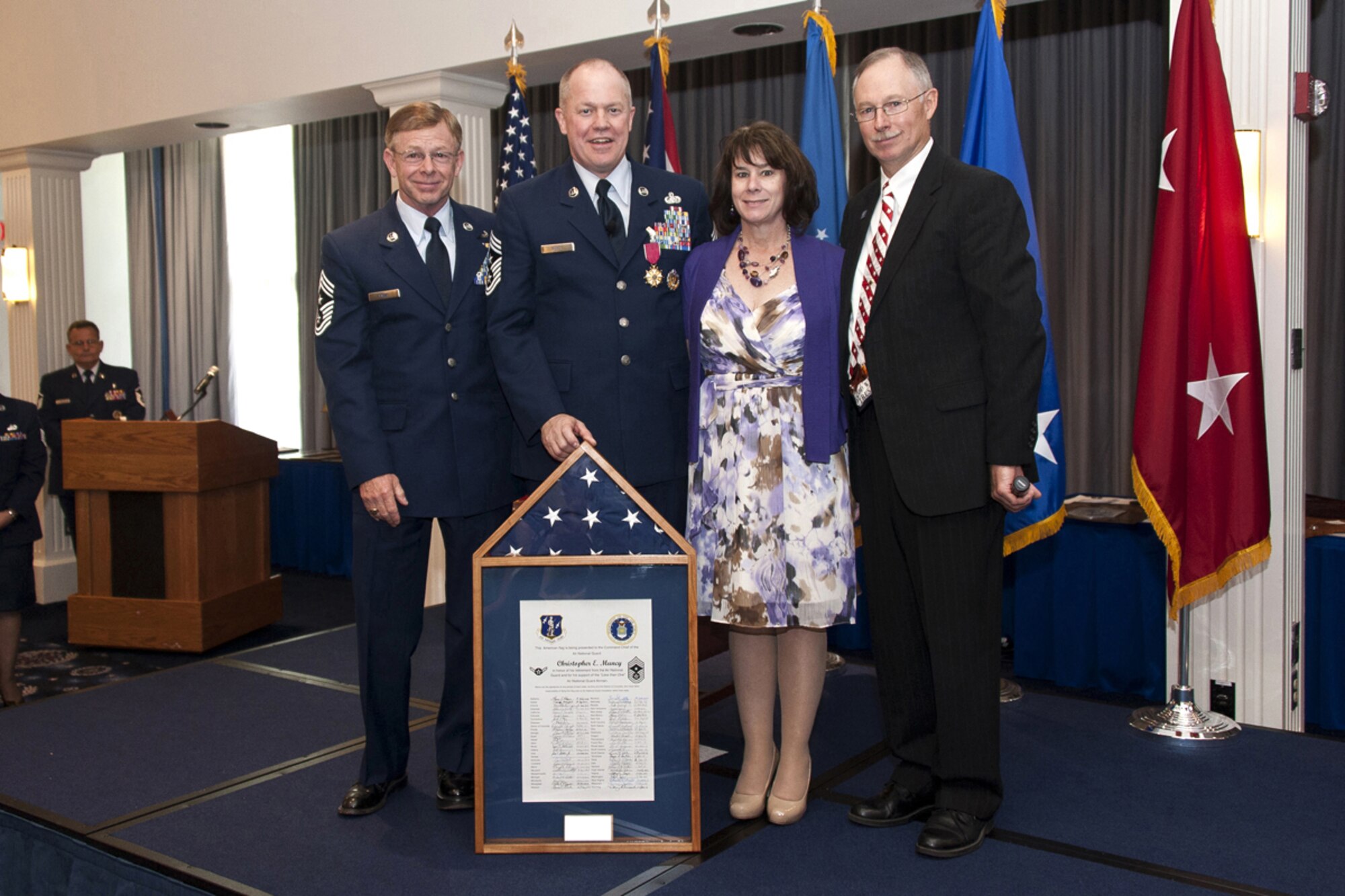 Chief Master Sgt. Christopher E. Muncy, Command Chief Master Sergeant of the Air National Guard, National Guard Bureau, Washington, D.C., poses with (left to right) Chief Master Sgt. Ronald Bowe, West Virginia Air National Guard Command Chief, Muncy's wife, Monique, and Chief Master Sgt. (Ret.) Michael Dalton, former Michigan Air National Guard Command Chief, after receiving a shadow box during his retirement luncheon at Joint Base Anacostia-Bolling on Sept. 25, 2012. The American flag encased in Muncy's shadow box was flown over all 54 U.S. states and territories.  (National Guard photo by Master Sgt. Marvin Preston/RELEASED)