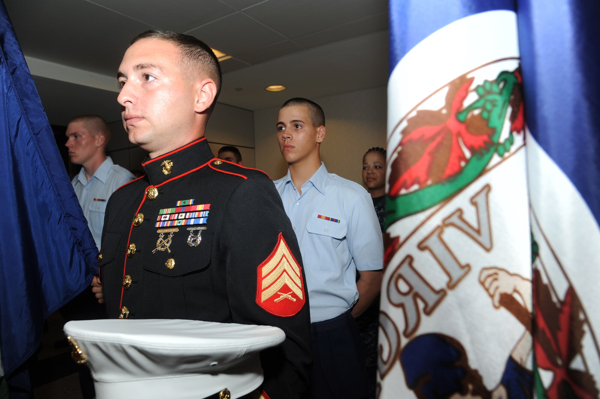 Sgt. Kenneth Molt, Keesler Marine Detachment, foreground, stands in formation as Airman 1st Class Michael Karr and Airman Basic Joseph Maldonado, 335th Training Squadron, Keesler Air Force Base, Miss., stand behind him holding two of the 50 state flags awaiting the arrival of WWII veterans at the fourth Mississippi Gulf Coast Honor Flight to Washington, D.C., Sept 25, 2012, at the Gulfport/Biloxi International Airport. The Honor Flight program receives donations to honor our nation’s World War II veterans by sending them on a one-day visit to Arlington National Cemetery in Washington, D.C.  (U.S. Air Force photo by Kemberly Groue)