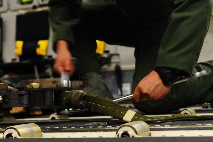 Senior Airman Brandon Killen, 437th Operations Support Squadron  loadmaster, tightens the bolts on a three point link Sept. 24, 2012, at Joint Base Charleston - Air Base, S.C. A three-point link connects the strap attached to the extraction package to the actual load. The bolt must be at least flush with the nut.  If there is a malfunction during this sequence, the load won’t leave the aircraft and there won’t be an airdrop. (U.S. Air Force photo/ Airman 1st Class Chacarra Walker)