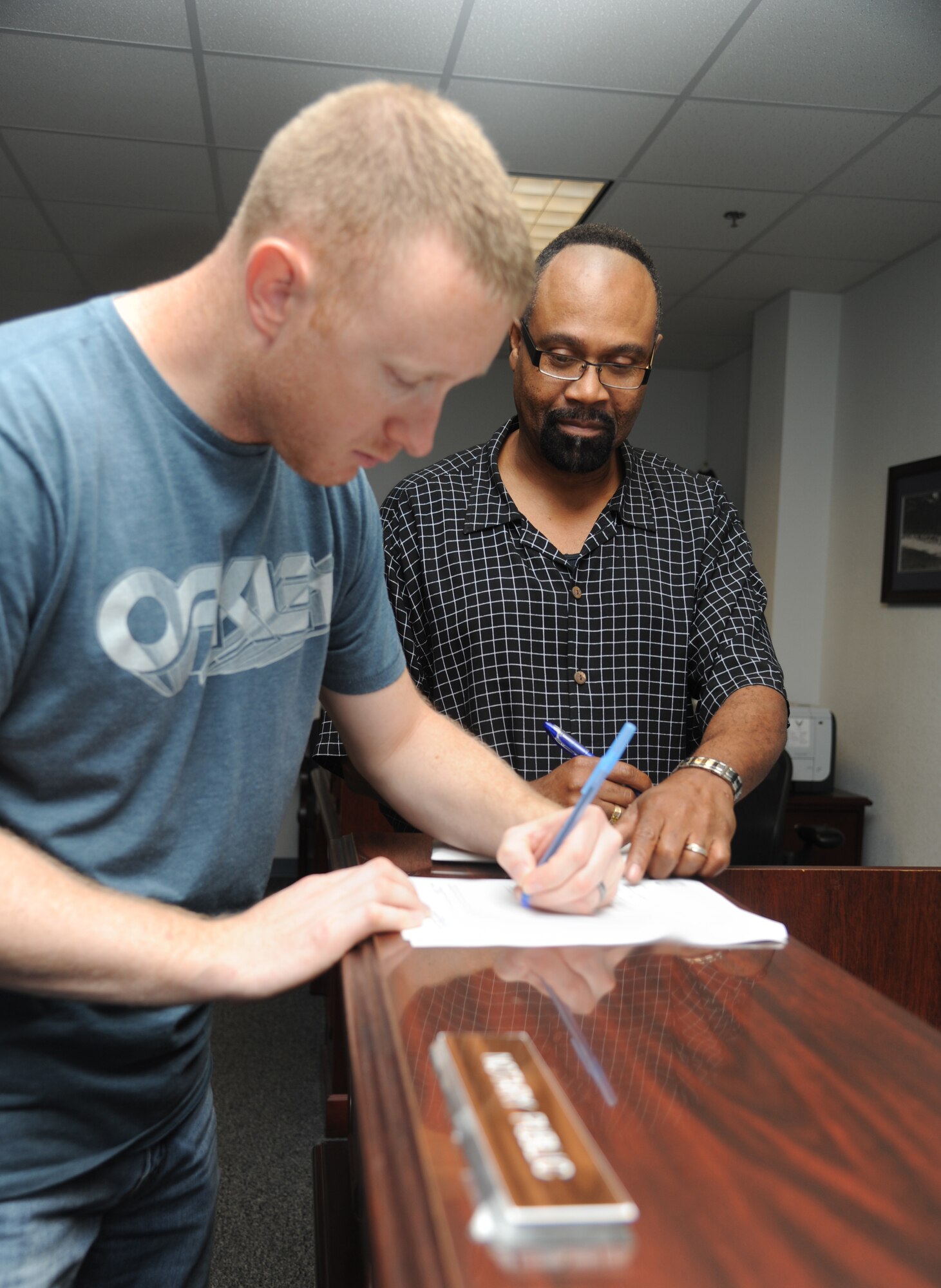 Staff Sgt. Johnathon Campton, 345th Airlift Squadron, receives assistance from Gregory Lewis, 81st Training Wing legal assistant and notary public, with a car registration form Sept. 25, 2012, at the Sablich Center, Keesler Air Force Base, Miss.  (U.S. Air Force photo by Kemberly Groue)