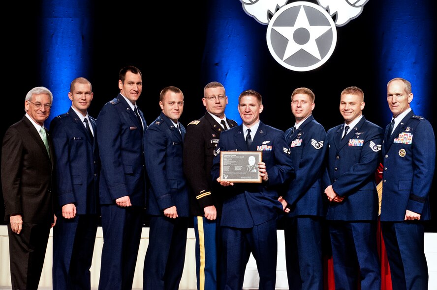 The aircrew of FEVER 11 is presented the Lt. Gen. William H. Tunner Award by Sandy Schlit, Chairman of the board for the Air Force Association (far left), and Gen. Mike Hostage, commander of Air Combat Command (far right), at the Annual Air and Space Conference and Technology Exposition award ceremony, Sept. 17, 2012 in Washington D.C. FEVER 11 was named the most outstanding airlift crew in the U.S. Air Force. The crew won the award for a casualty evacuation mission they performed Dec. 24, 2011, while deployed to Afghanistan. (U.S. Air Force photo by Staff Sgt. Joshua J. Garcia/Released) 
