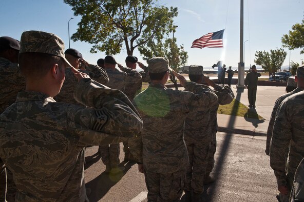 Airmen salute the American flag as it is lowered by the Ellsworth Air Force Base Honor Guard during a Prisoner of War, Missing in Action Remembrance retreat ceremony at Ellsworth Air Force Base, S.D., Sept. 22, 2012. Events throughout the day were dedicated to remembering America’s POWs and MIAs. (U.S. Air Force photo by Airman 1st Class Zachary Hada/Released)