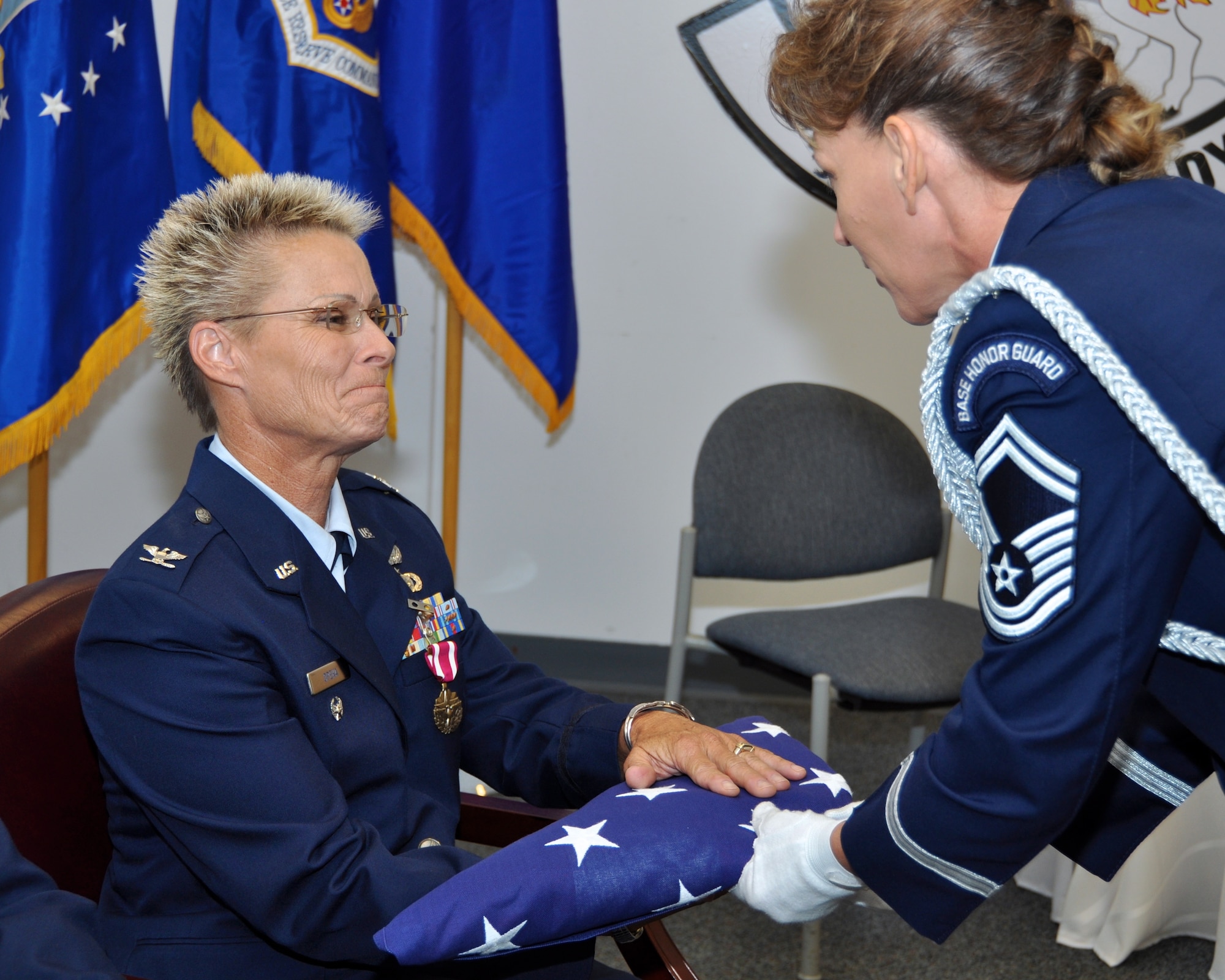 Senior Master Sgt. Gina Louis presents a retirement flag to Col. Sandra Opeka Sept. 8, 2012 at Joint Base Naval Air Station Fort Worth, Texas. Opeka was one of Louis’ mentors in the Air force Reserve, and they originally met during a conference for Women in Aviation. Louis is a 315th Airlift Wing Aircraft Maintenance Squadron production superintendent, honor guard NCO in charge, a member of the mini C-17 team, and actively participates in Women in Aviation. (U.S. Air Force courtesy photo)
