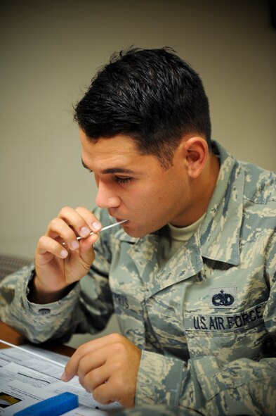 U.S. Air Force Staff Sgt. Charles Harris, 23d Component Maintenance Squadron aerospace propulsion craftsman, swabs his cheeks during Moody’s Bone Marrow Drive at Moody Air Force Base, Ga., Sept. 24, 2012.. Donor volunteers must be in good health and between the ages of 18 and 60 to register. (U.S. Air Force photo by Senior Airman Douglas Ellis/Released) 
