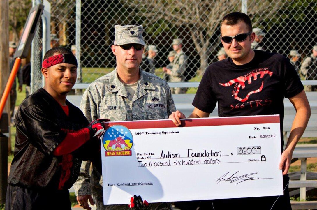The 366th Training Squadron presented a check for $2,600 to the Autism Speaks foundation at the third annual "Instructor versus Airman-in-Training" Combinded Federal Campaign flag football game on Sept. 21. The Instructors won the game this year with a 19-13 victory. Pictured from left to right: AiT team captain A1C Andre Lejia-Brown, LtCol James Beam, 366th TRS Commander, and Instructor team captain TSgt Derek Allar. (Courtesy photo)