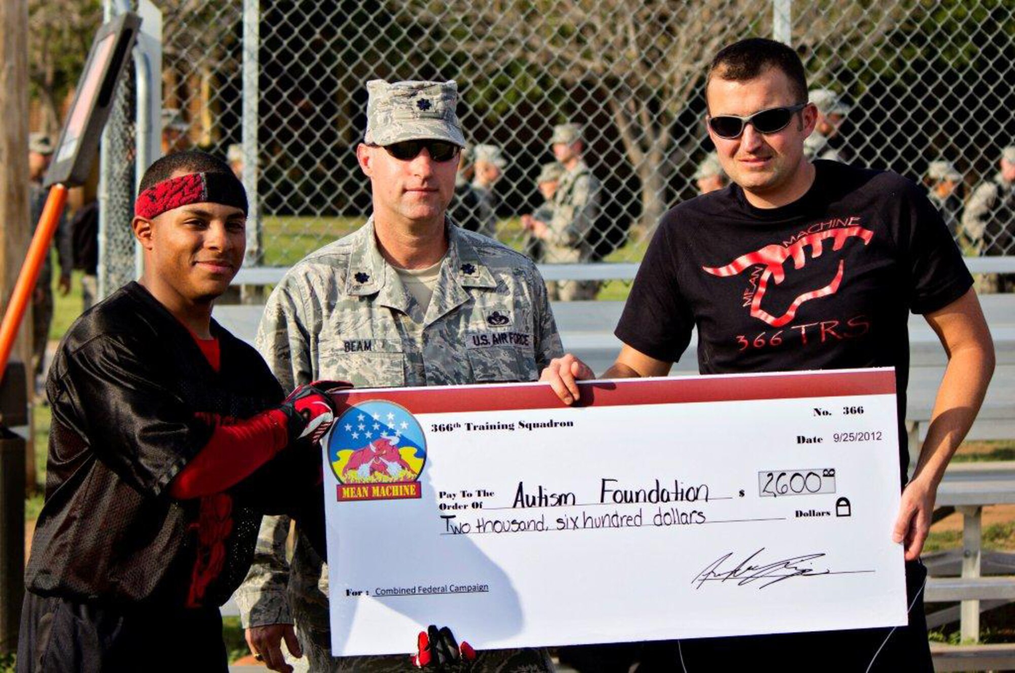 The 366th Training Squadron presented a check for $2,600 to the Autism Speaks foundation at the third annual "Instructor versus Airman-in-Training" Combinded Federal Campaign flag football game on Sept. 21. The Instructors won the game this year with a 19-13 victory. Pictured from left to right: AiT team captain A1C Andre Lejia-Brown, LtCol James Beam, 366th TRS Commander, and Instructor team captain TSgt Derek Allar. (Courtesy photo)